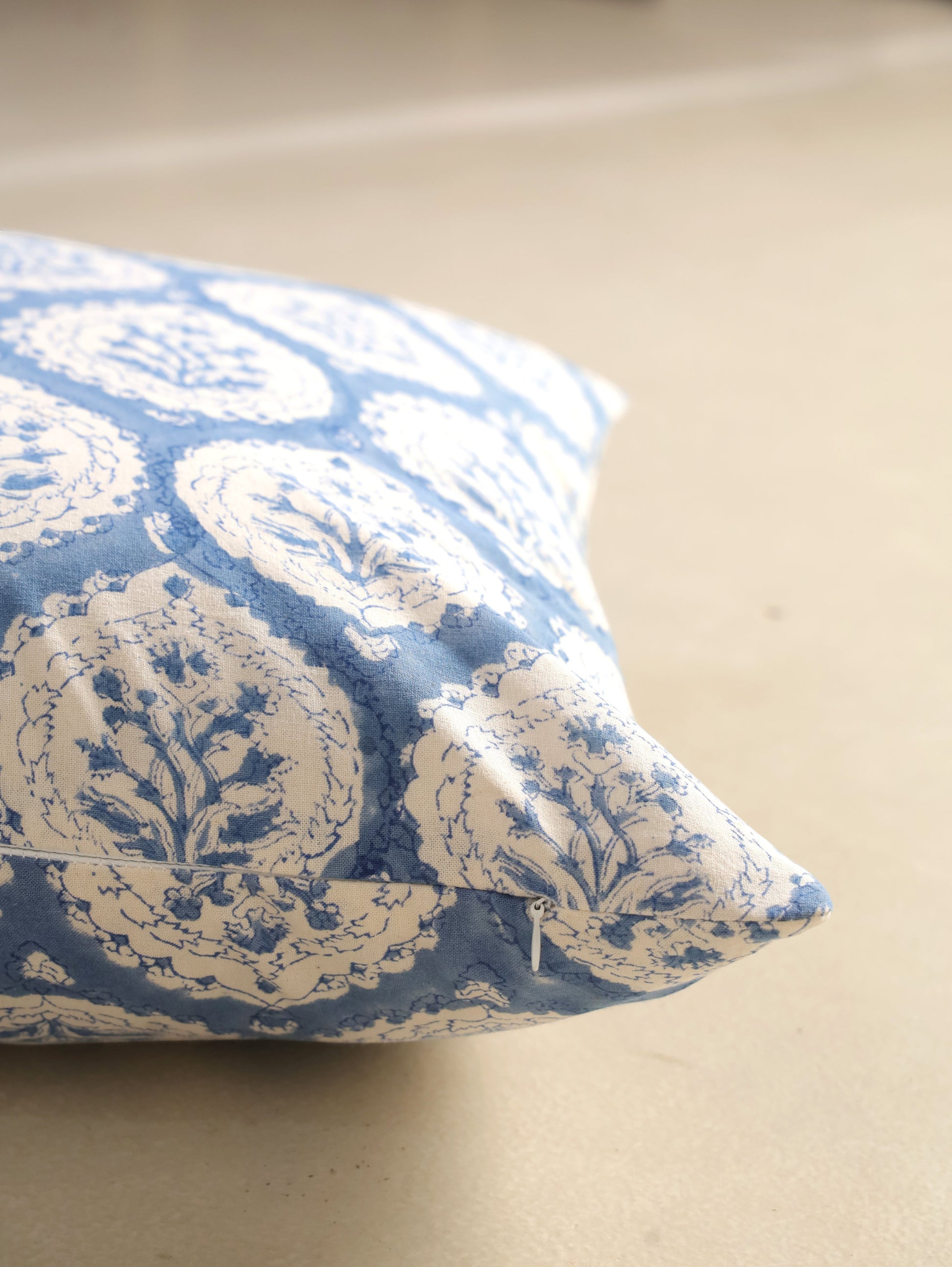 The Block & Bloom dusty blue cotton cushion cover with hand block printed floral buta motifs and scalloped frames.