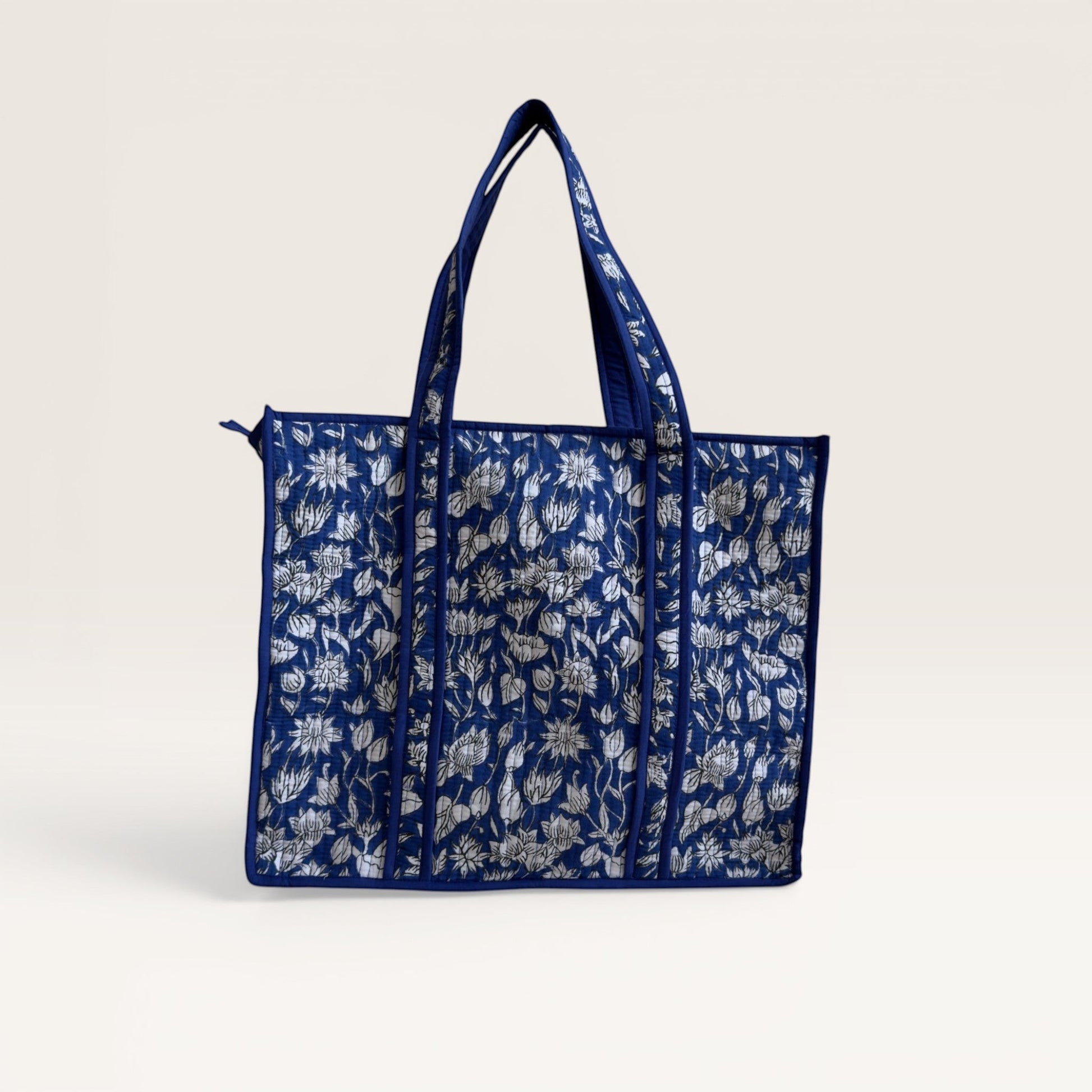 The Block & Bloom cobalt blue quilted tote bag featuring a white lotus hand block print and structured base.
