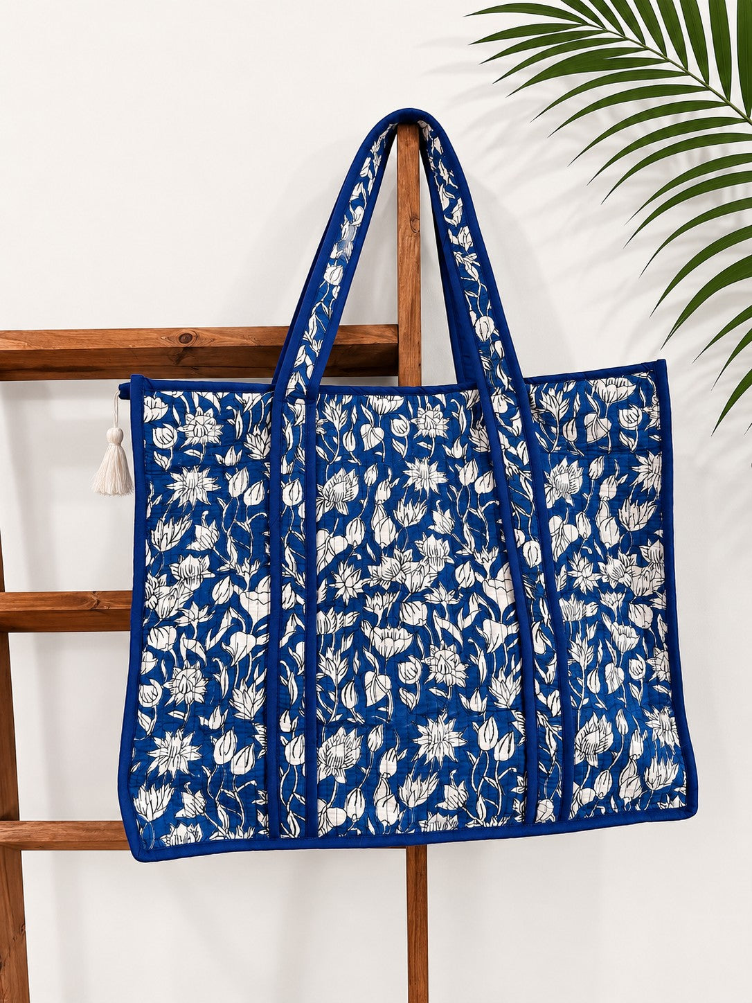 The Block & Bloom cobalt blue quilted tote bag featuring a white lotus hand block print and structured base.