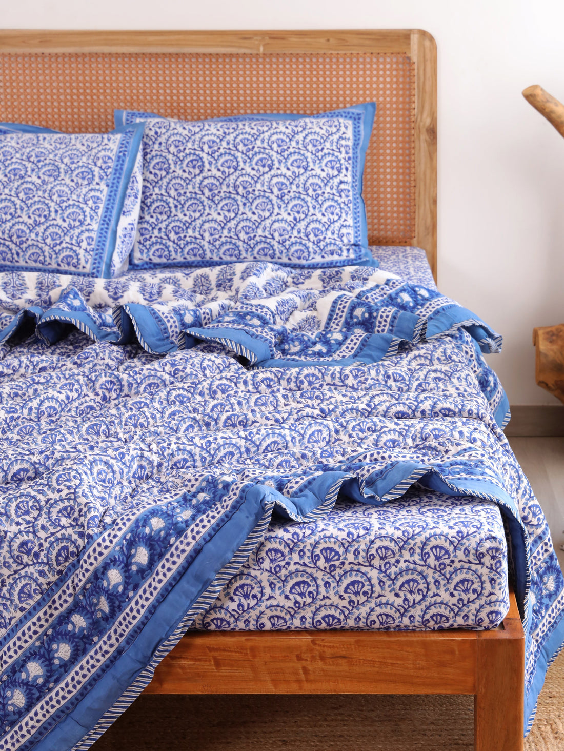 The Block & Bloom Blue Vine Bloom 4pc cotton bedding set with blue and white floral vine print on a wooden bed frame.