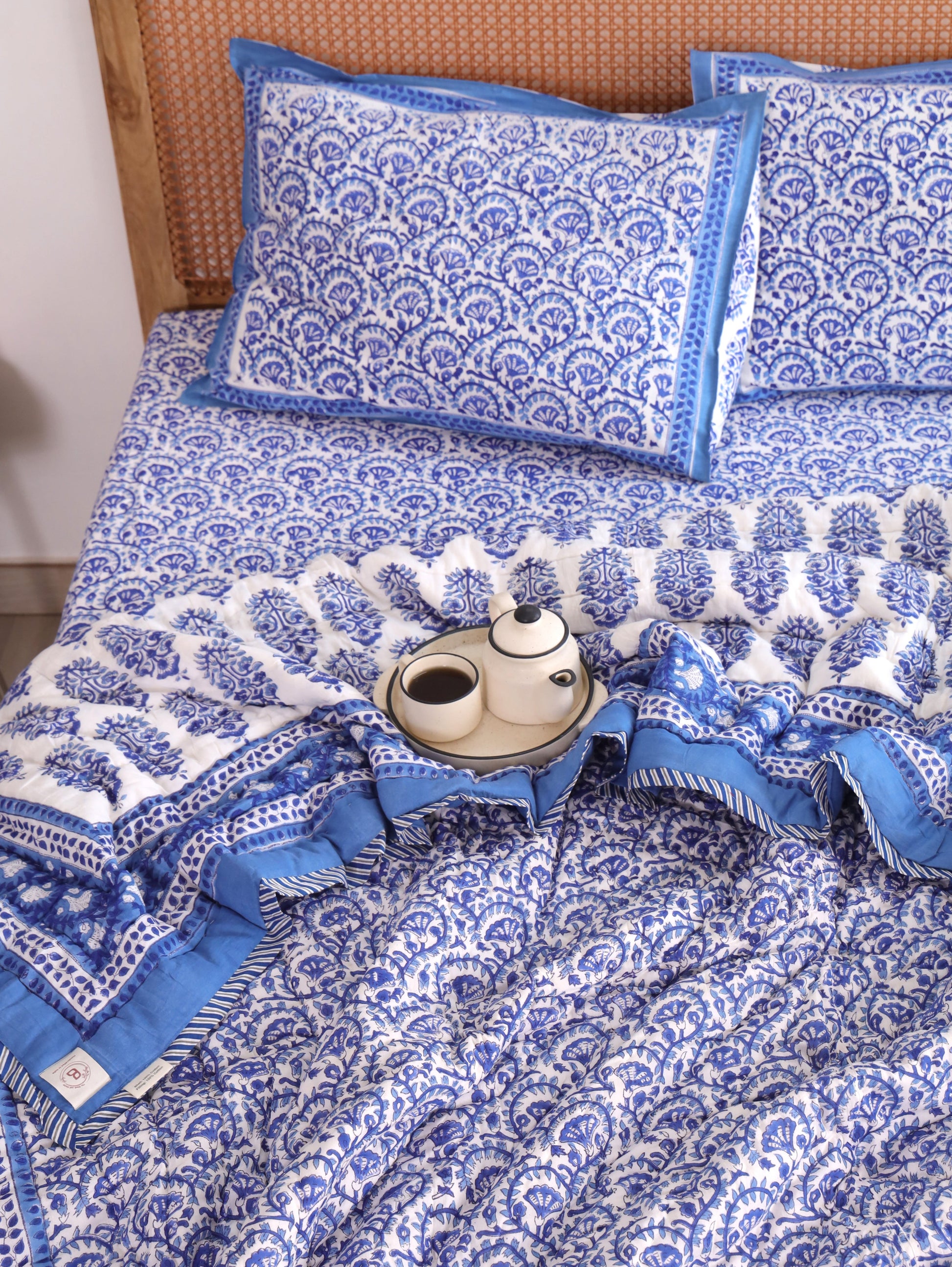 The Block & Bloom Blue Vine Bloom 4pc cotton bedding set with blue and white floral vine print and solid blue borders.