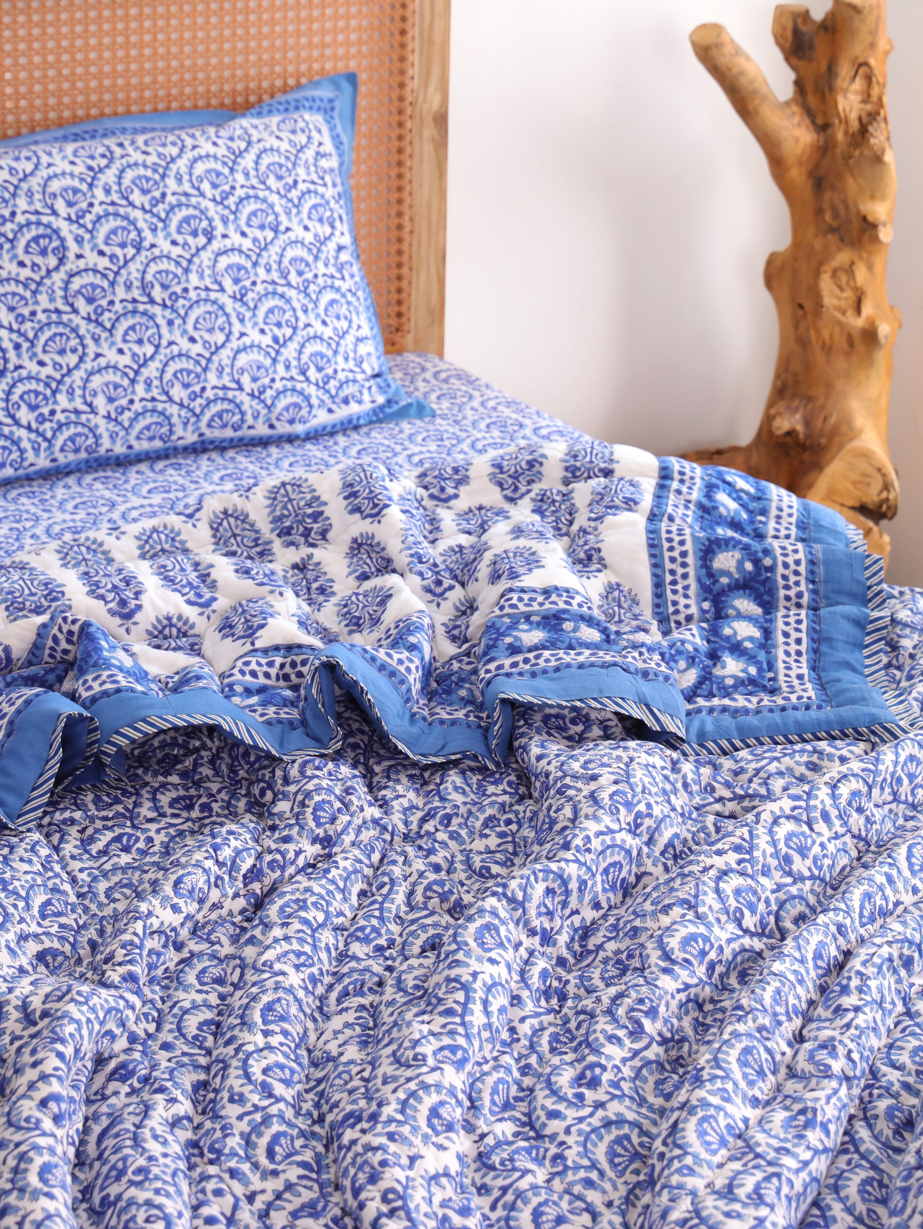 The Block & Bloom blue and white vine print cotton quilt and pillowcase set with a solid blue border.