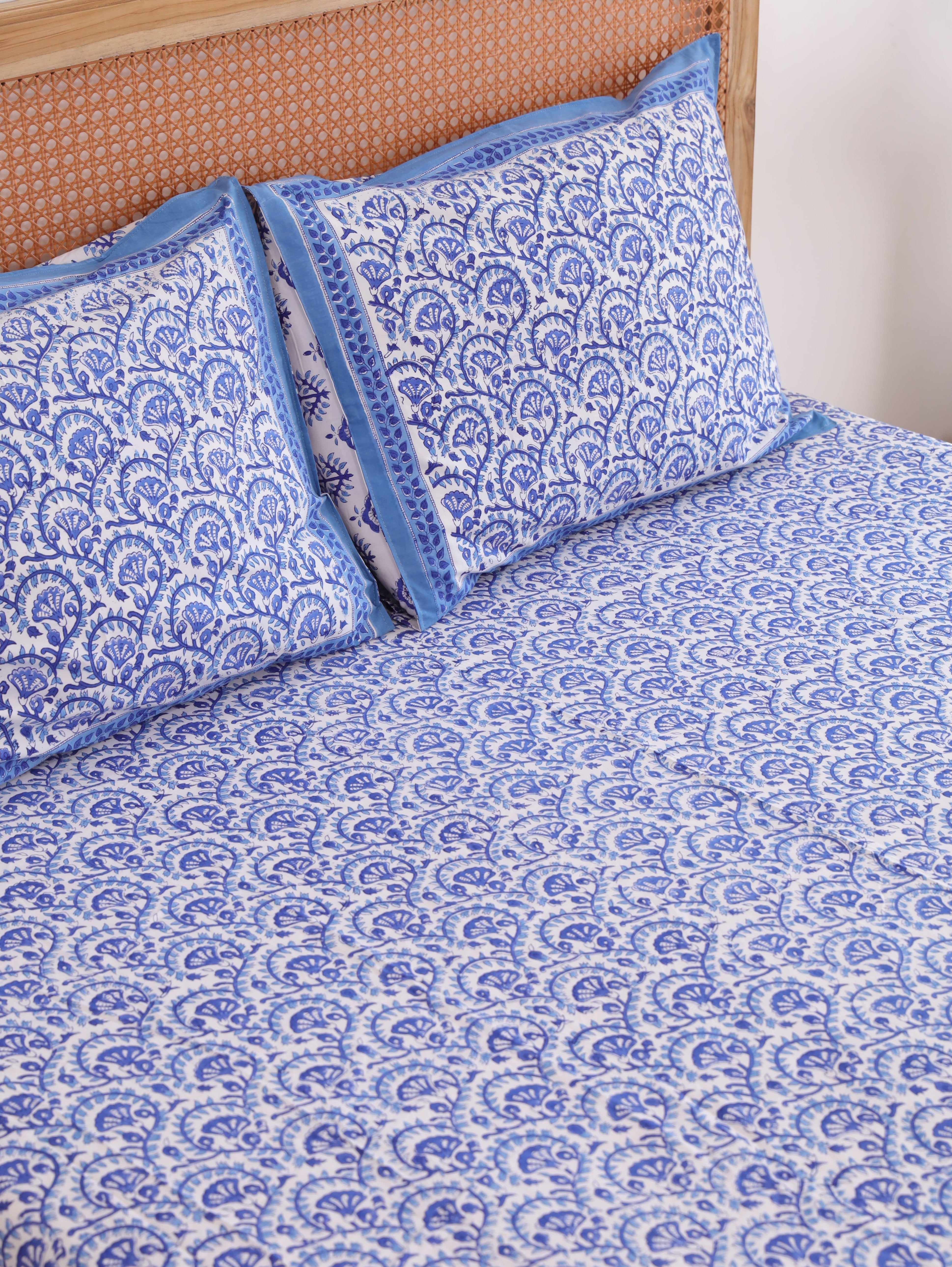 The Block & Bloom Blue Vine Bloom cotton percale fitted sheet and matching pillowcases with blue block print pattern.