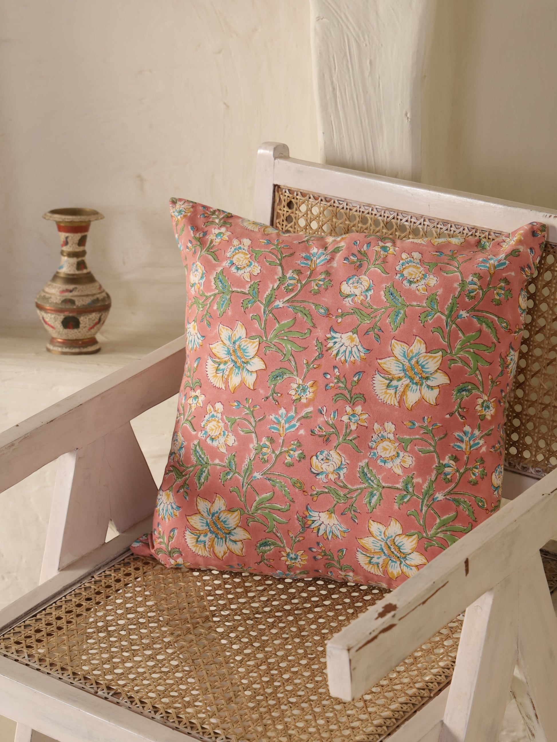 The Block & Bloom Blush Bloom cotton cushion cover with floral print in white, yellow, and teal on a dusty rose base.