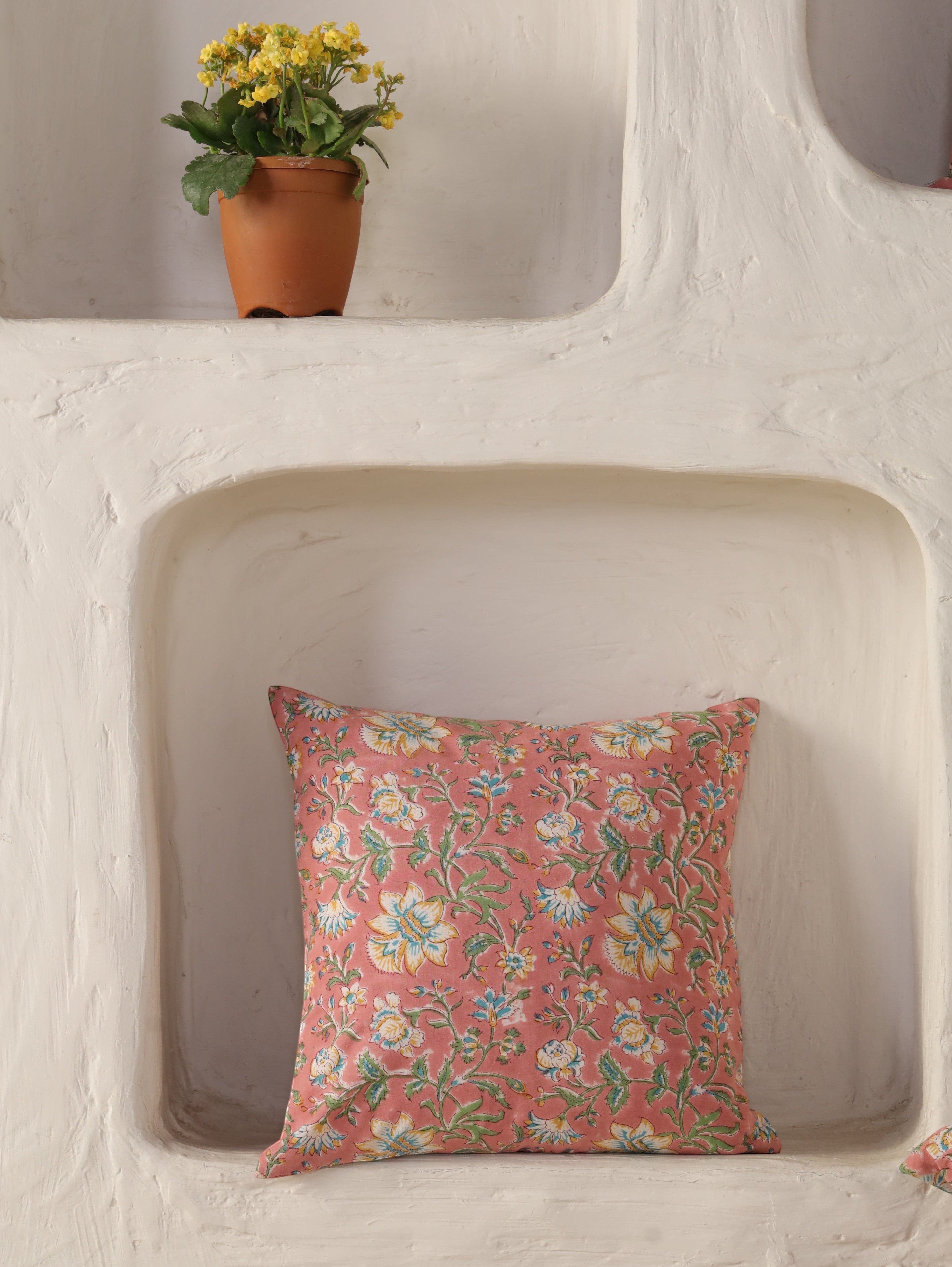 The Block & Bloom Blush Bloom cotton cushion cover with floral print in dusty rose, yellow, and teal in a wall niche.