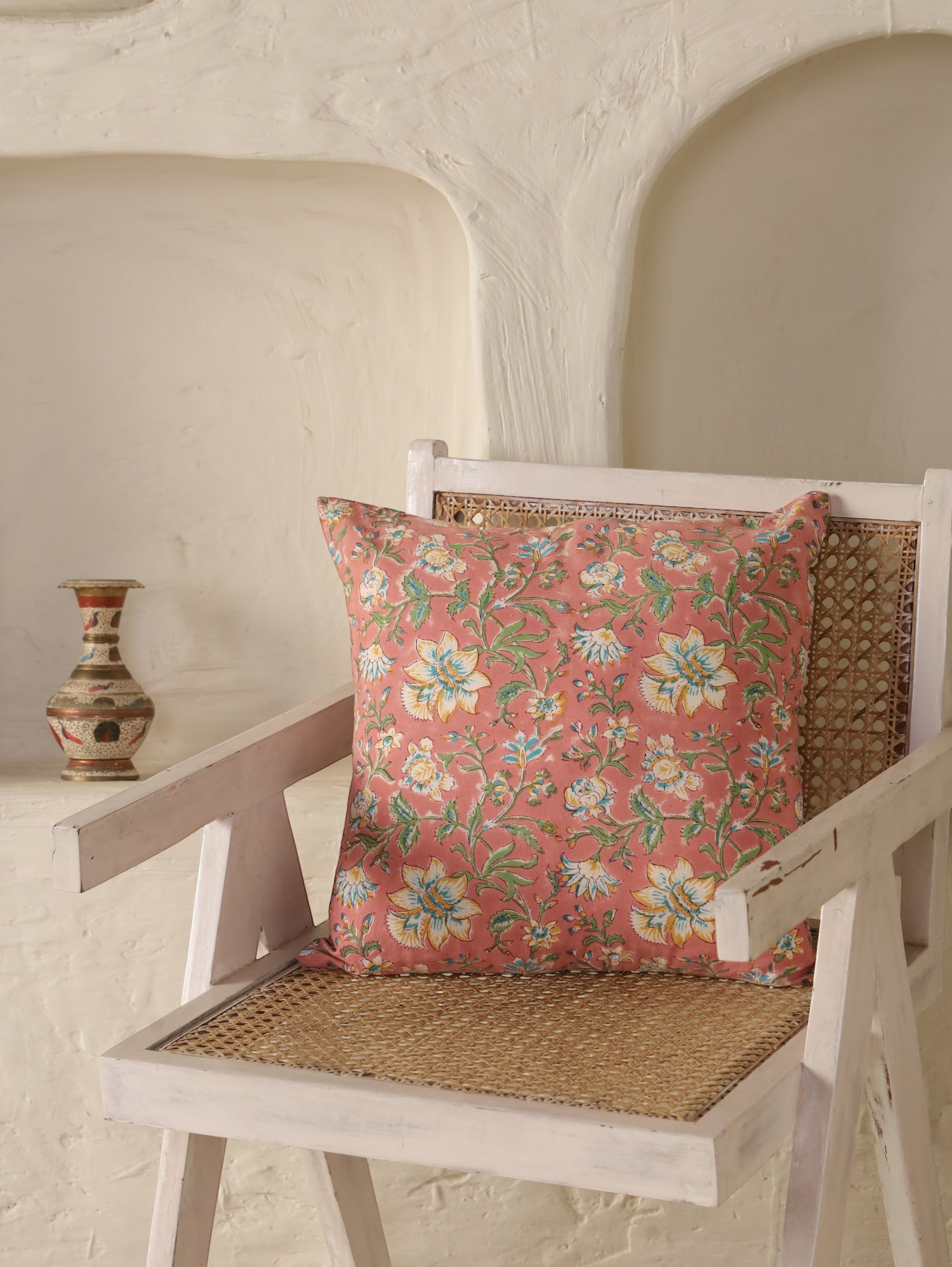 The Block & Bloom Blush Bloom cotton cushion cover with floral print in white, yellow, and teal on a dusty rose ground.