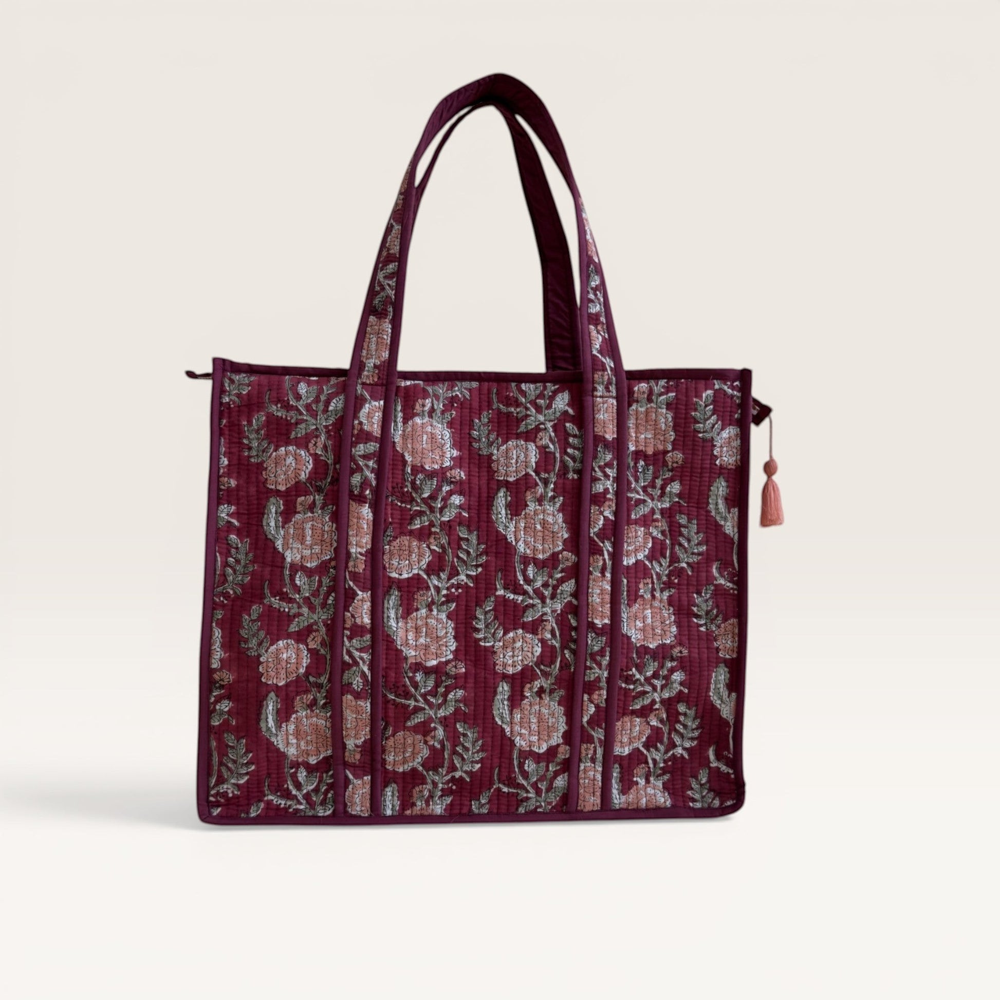The Block & Bloom burgundy quilted tote bag with pink rose floral print and green foliage, featuring a structured base.