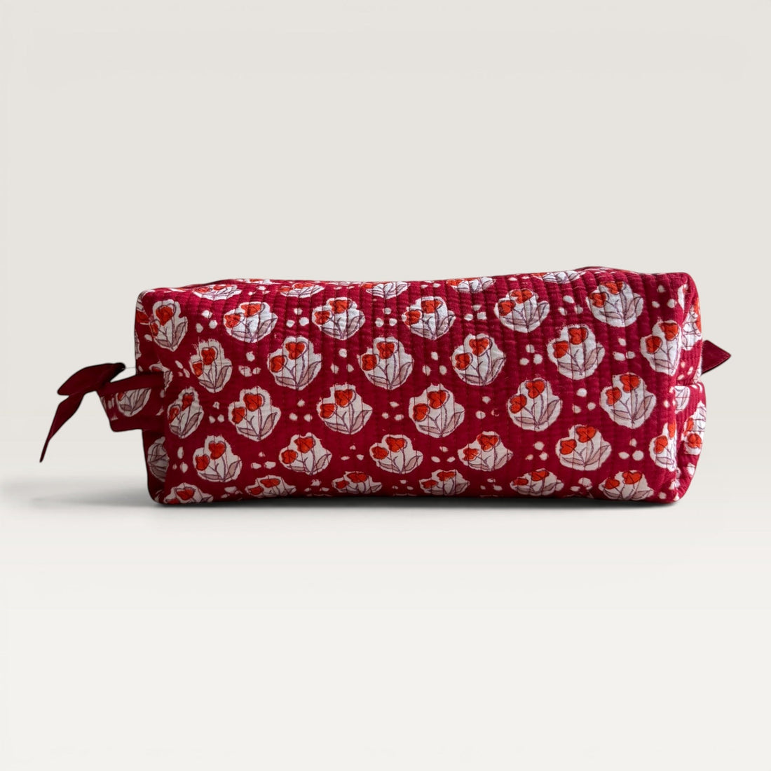 The Block & Bloom Cherry Bloom quilted hair tool organizer bag in burgundy red with white tulip and dot print.