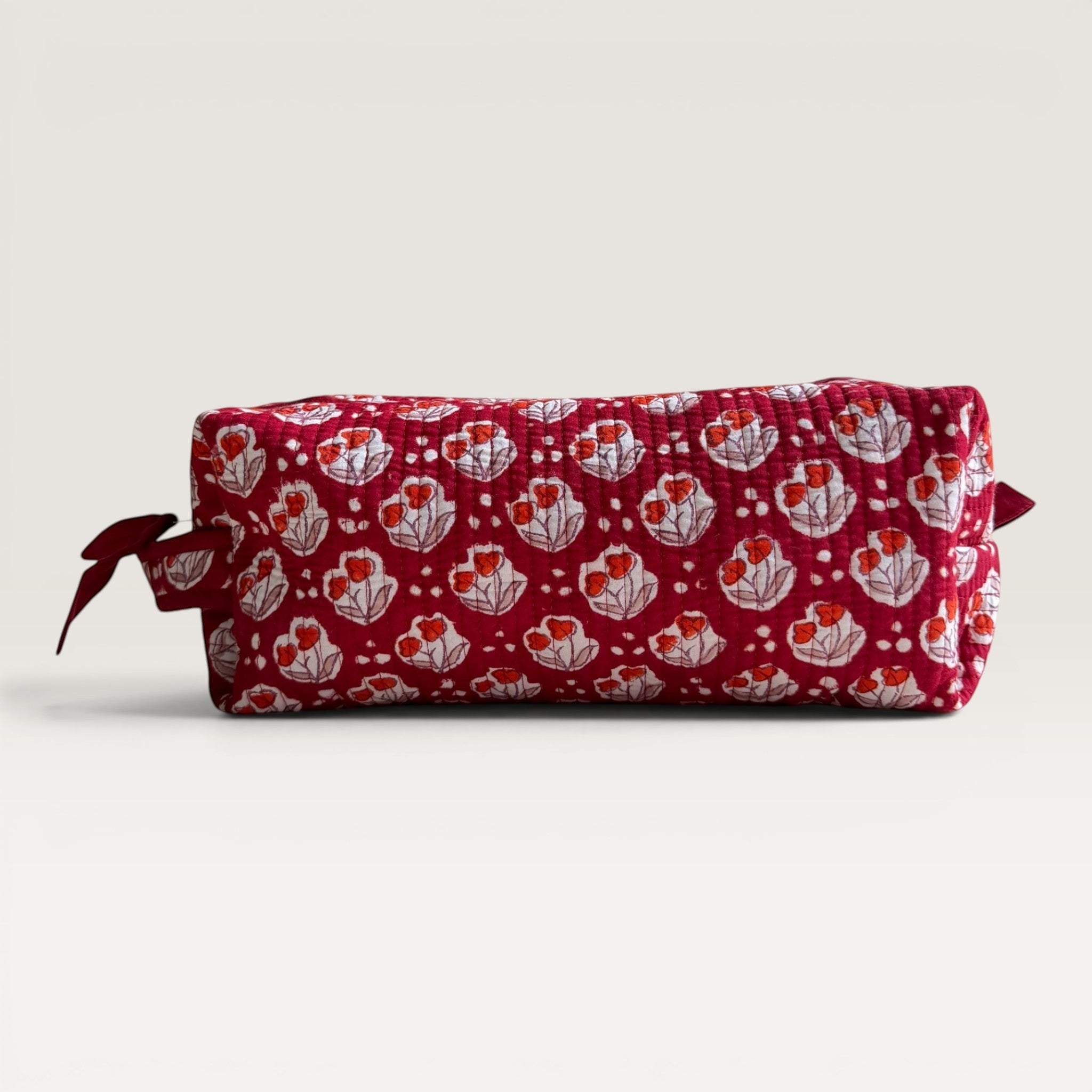 The Block & Bloom Cherry Bloom quilted hair tool organizer bag in burgundy red with white tulip and dot print.