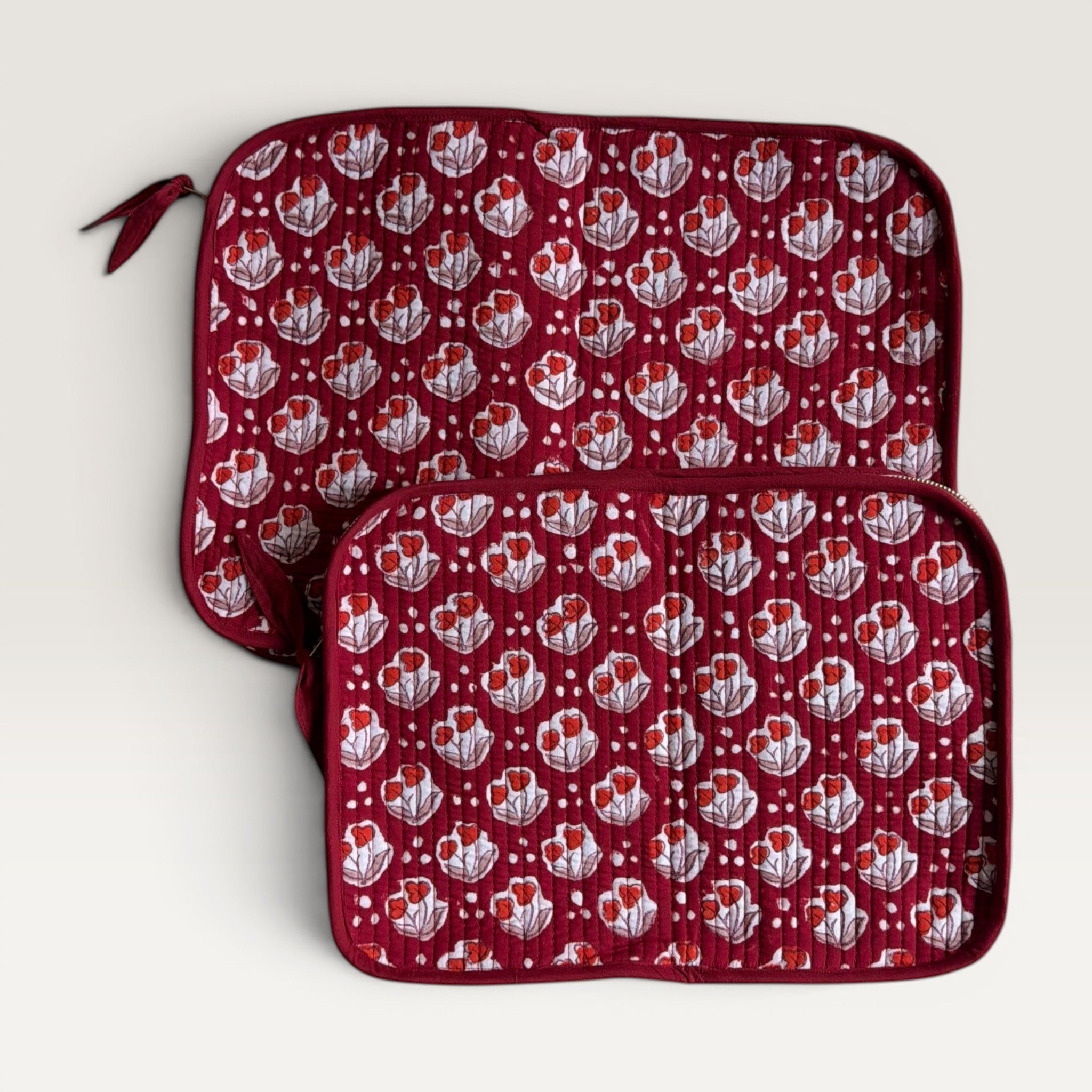 The Block & Bloom quilted laptop sleeve in burgundy red with red tulip motifs and white dot accents.