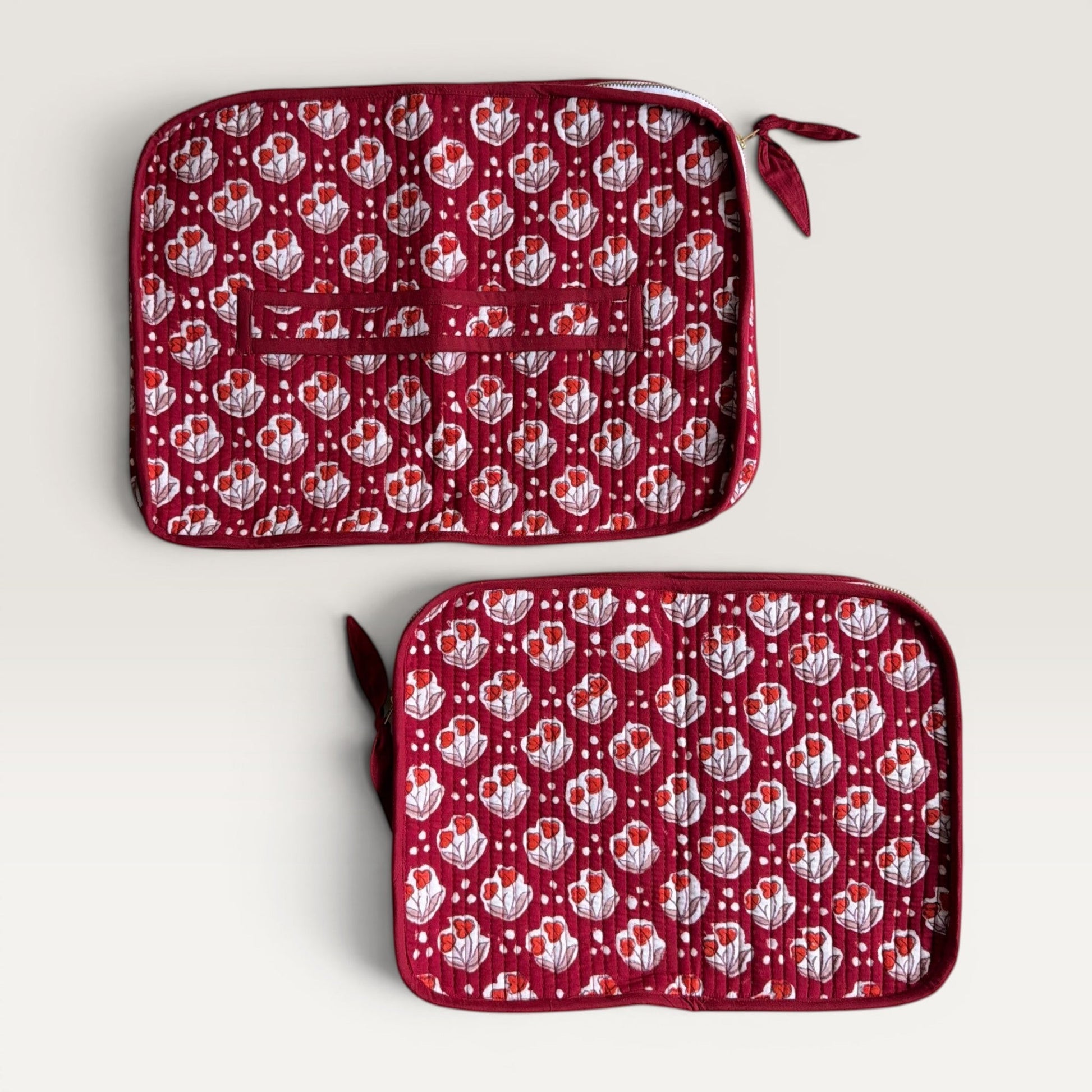 The Block & Bloom Cherry Bloom quilted laptop sleeve in burgundy red with red tulip motifs and a fabric bow zipper.