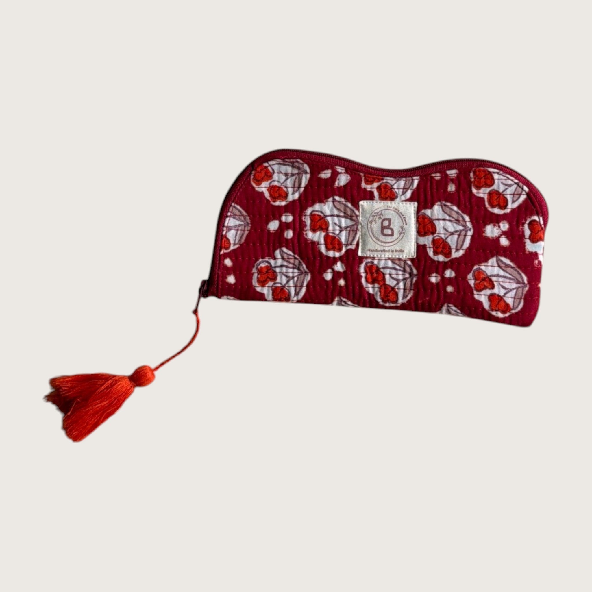 The Block & Bloom burgundy quilted cotton sunglasses pouch with red tulip motifs and a matching red tassel zipper.