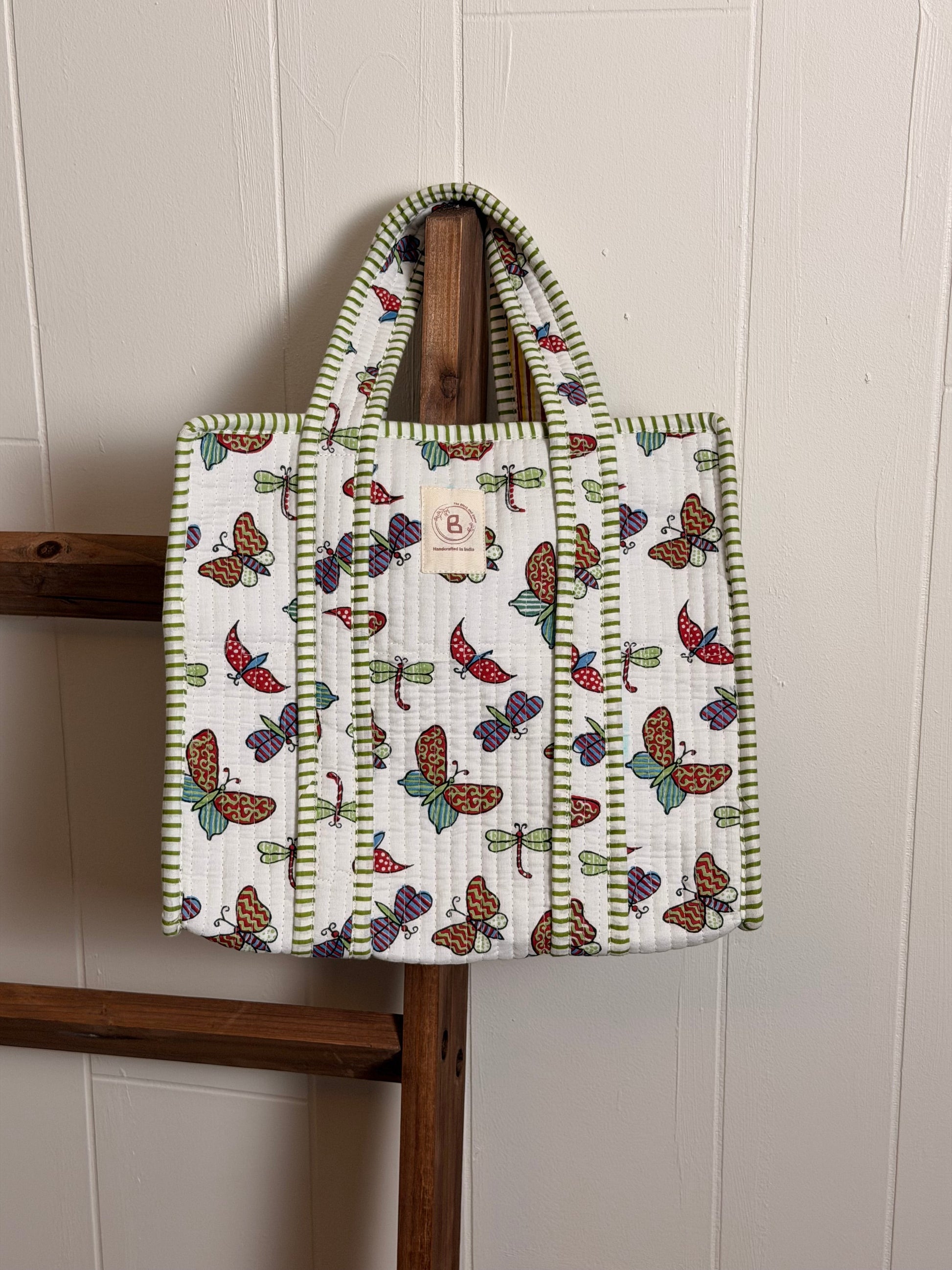 The Block & Bloom quilted mini tote featuring a white fabric with hand block-printed colorful butterflies and dragonflies.