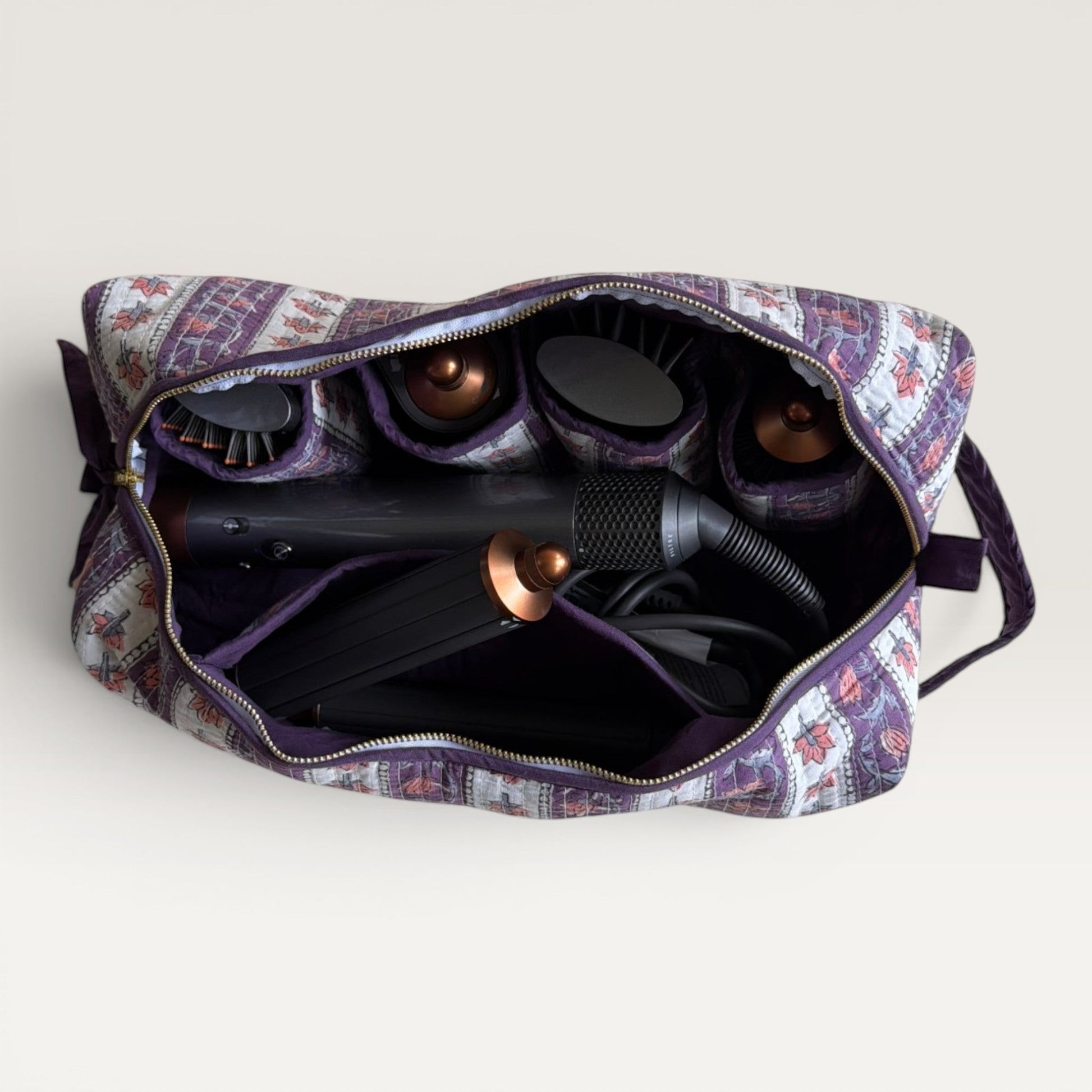 The Block & Bloom Cherry Bloom hair tool organizer bag in burgundy quilted fabric with red tulip motifs and inner slots.