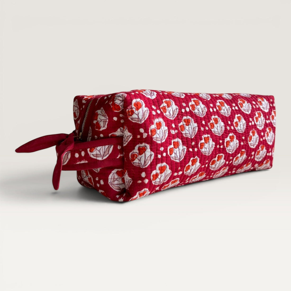The Block & Bloom Cherry Bloom quilted hair tool organizer bag in burgundy red with white tulip and dot print.