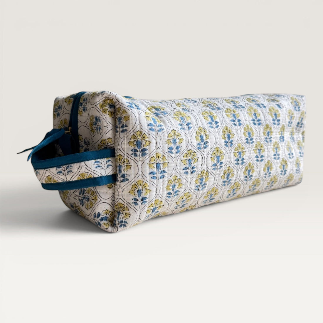 The Block & Bloom Cosmos Tile quilted hair tool organizer bag with blue and yellow floral motifs on white fabric.