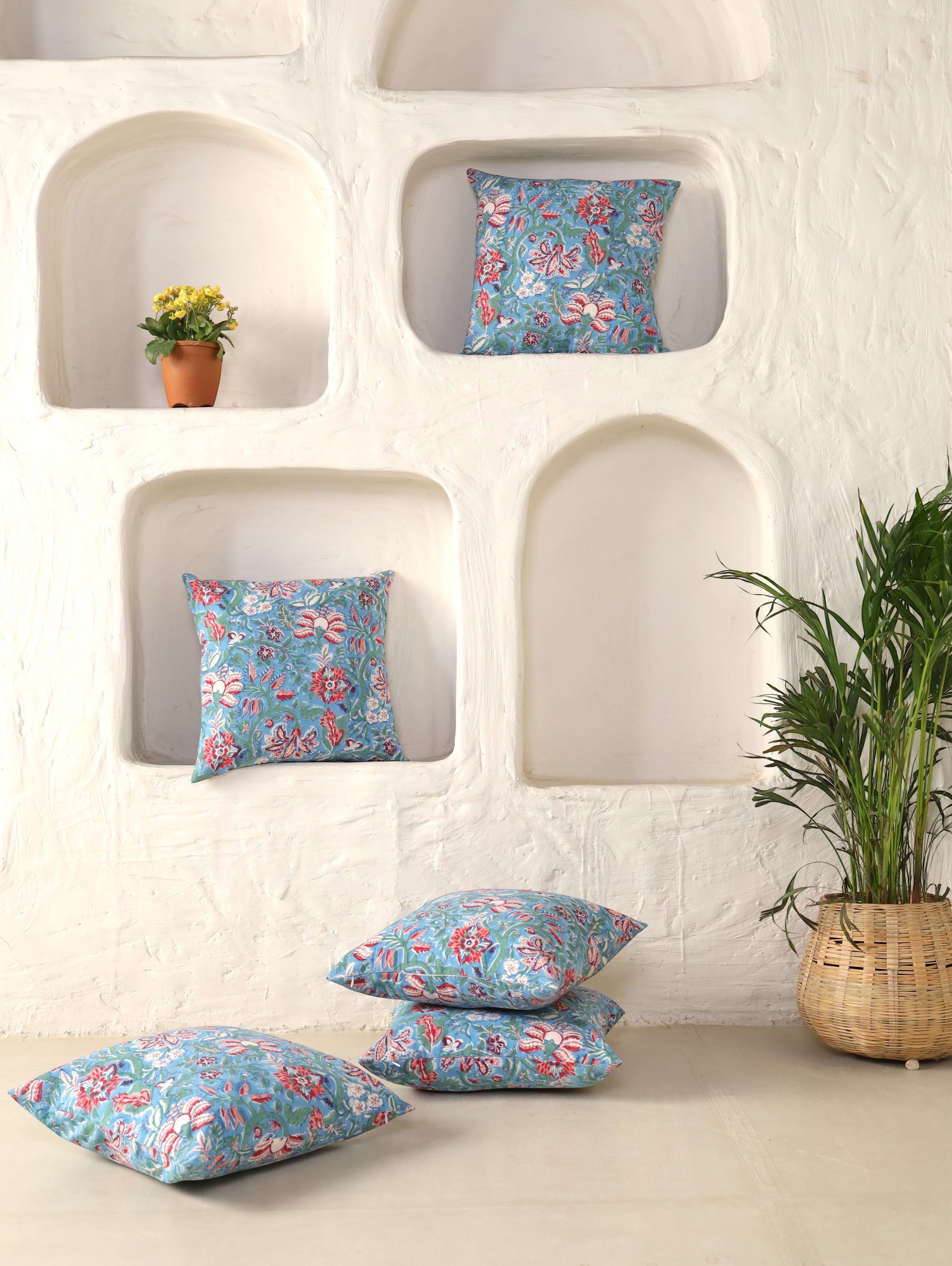 The Block & Bloom hand block printed cotton cushion cover featuring red and rose floral patterns on cornflower blue.
