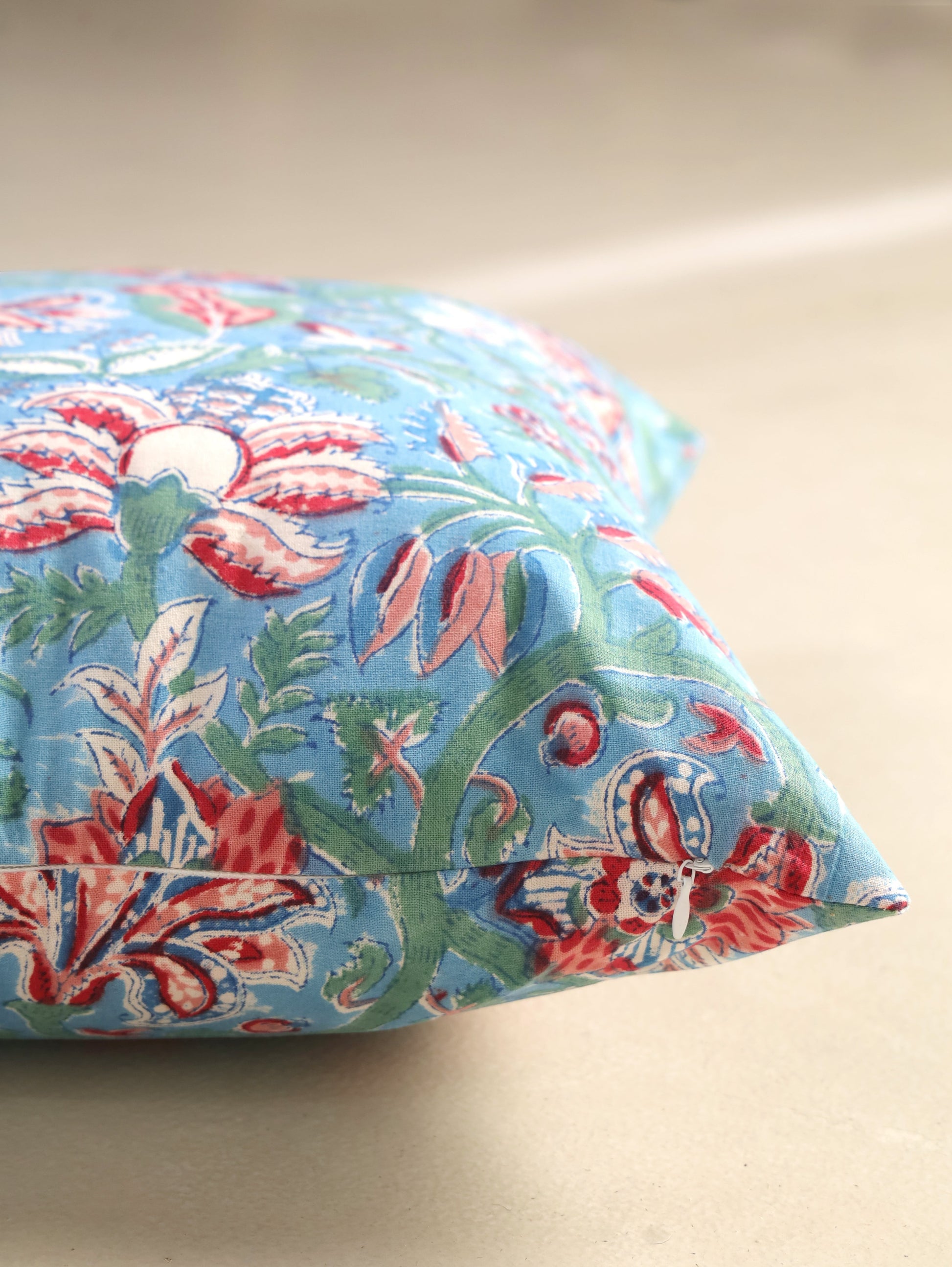 The Block & Bloom hand block printed cotton cushion cover in cornflower blue with red and rose floral patterns.