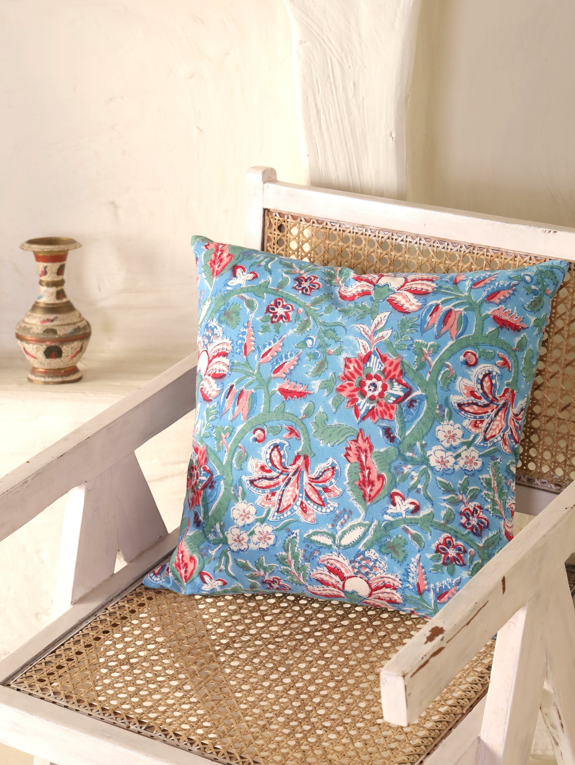 The Block & Bloom hand block printed cotton cushion cover featuring red and rose floral patterns on cornflower blue.
