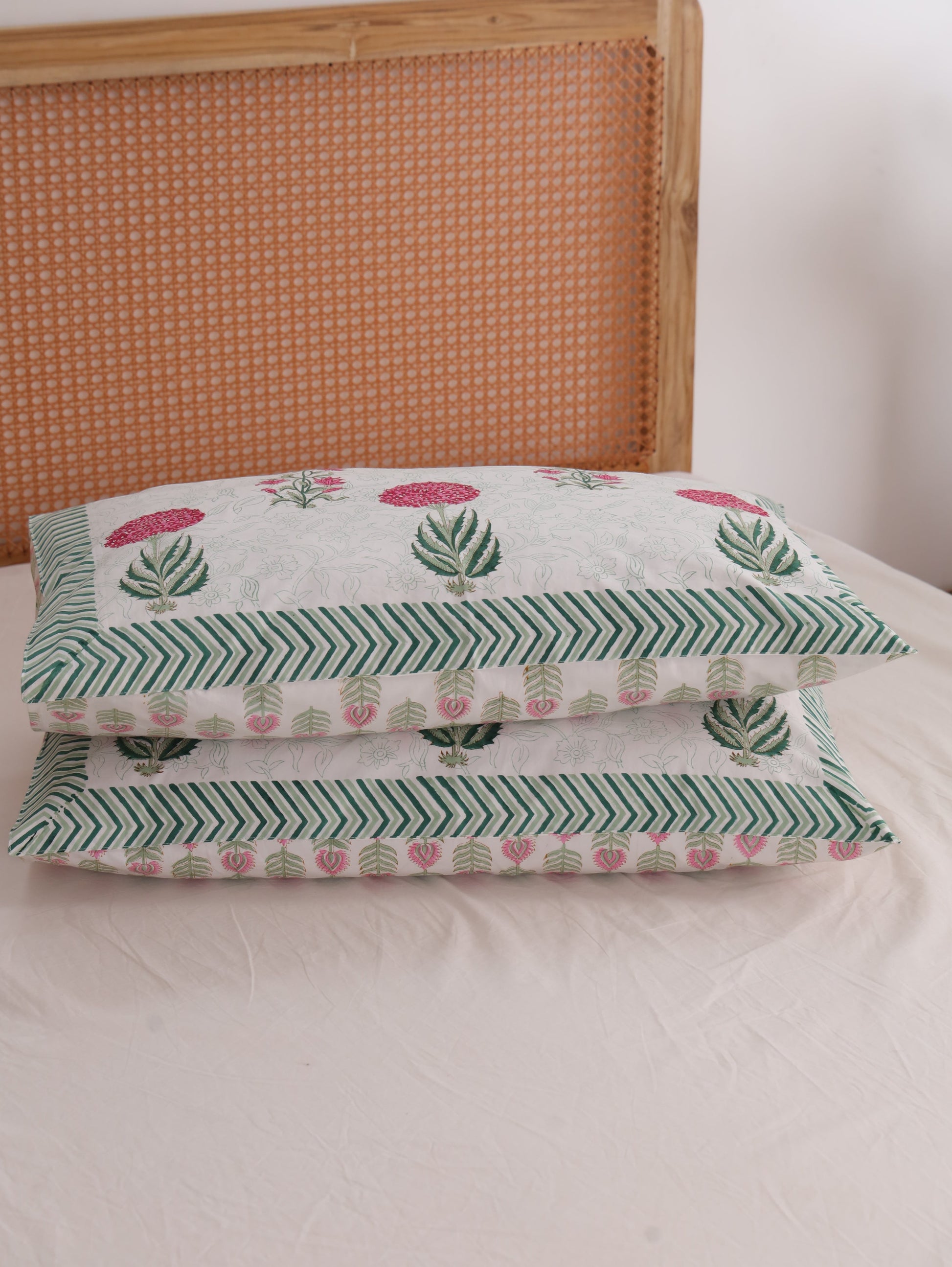 The Block & Bloom hand block printed cotton percale pillowcases with pink peony and lily floral motifs and green borders