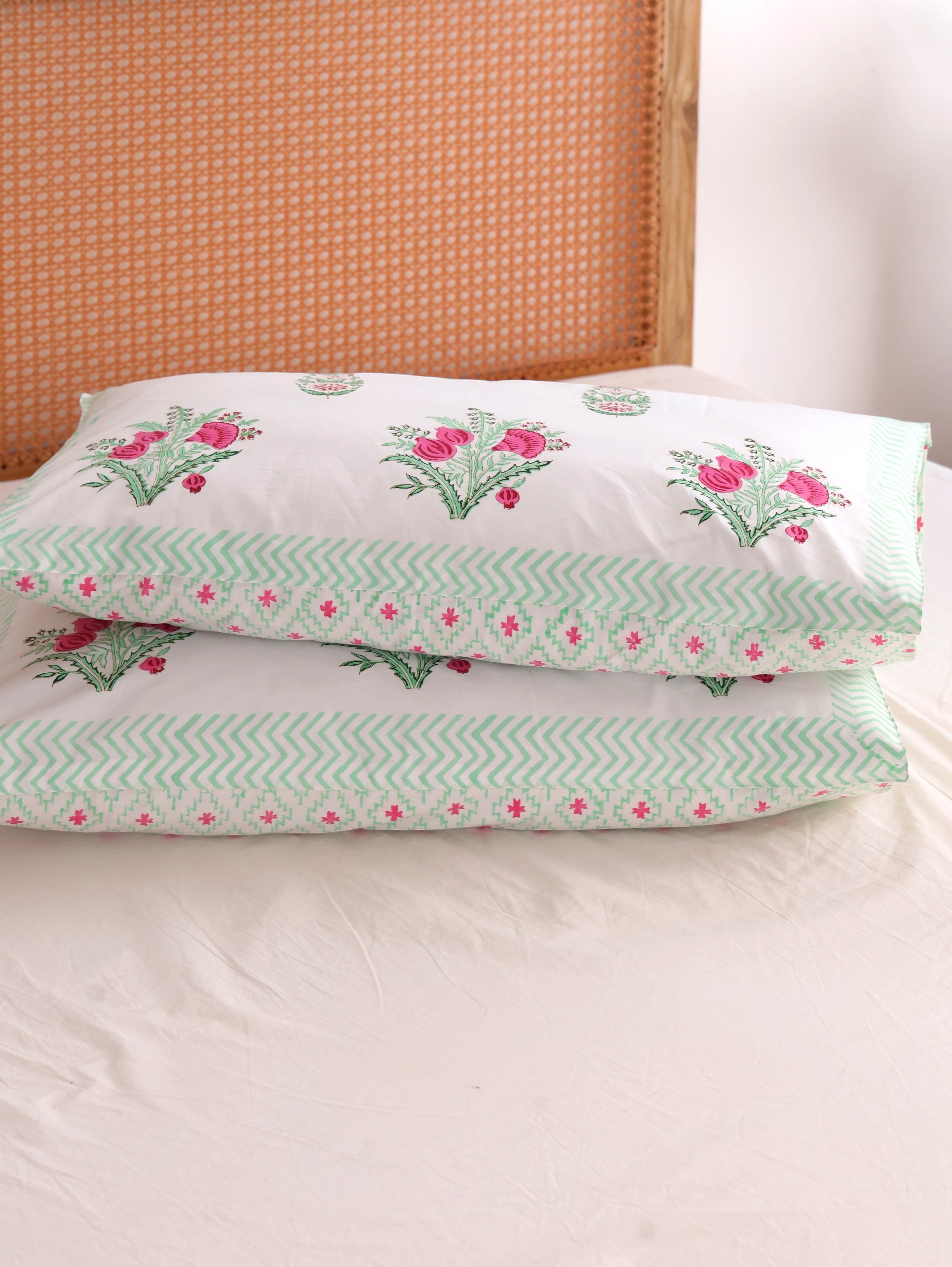 The Block & Bloom hand block printed cotton pillowcases with pink pomegranate floral print and green chevron border.