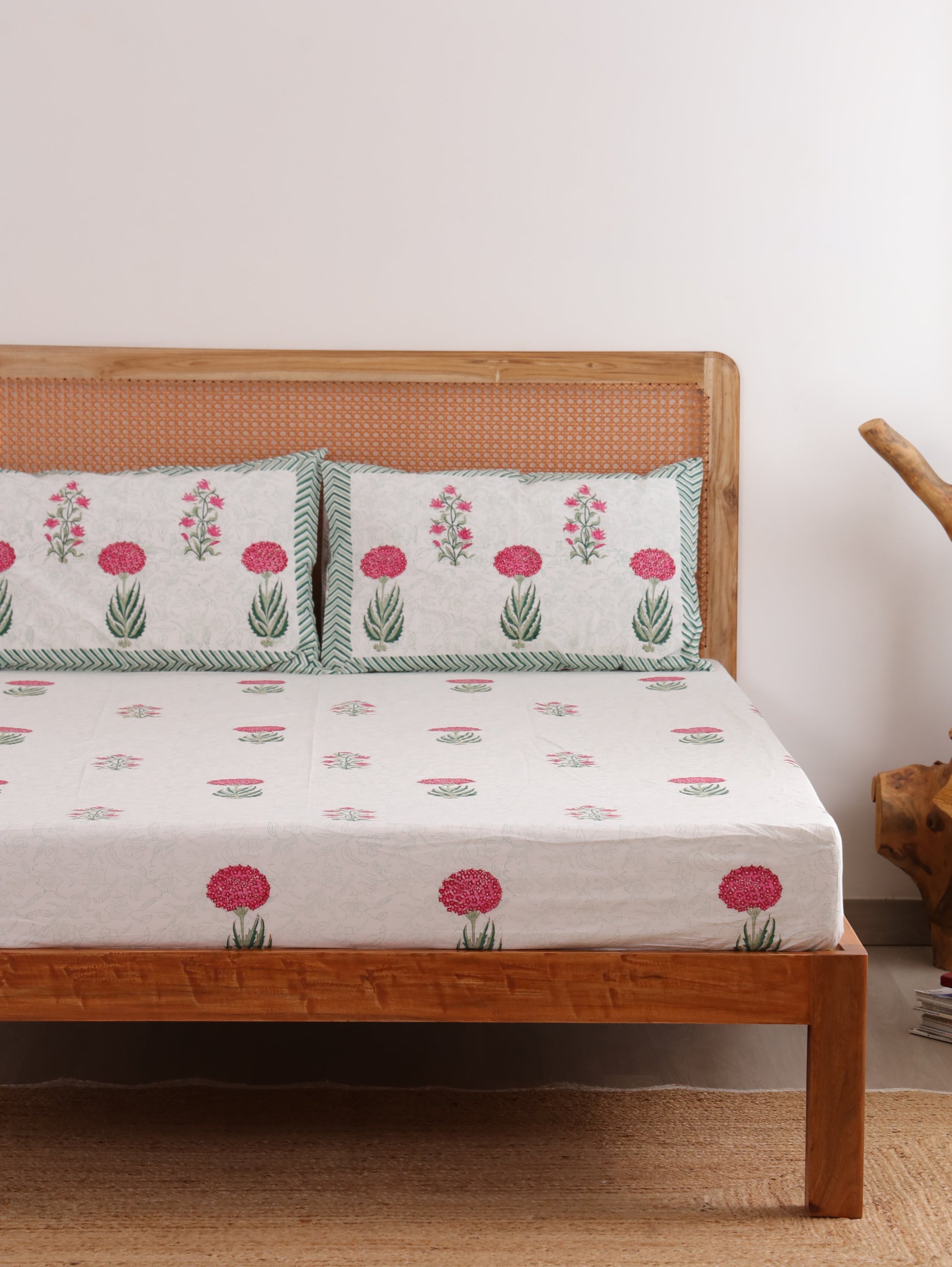 The Block & Bloom Spring Bloom fitted cotton percale bedsheet set with pink floral print and green striped pillows.