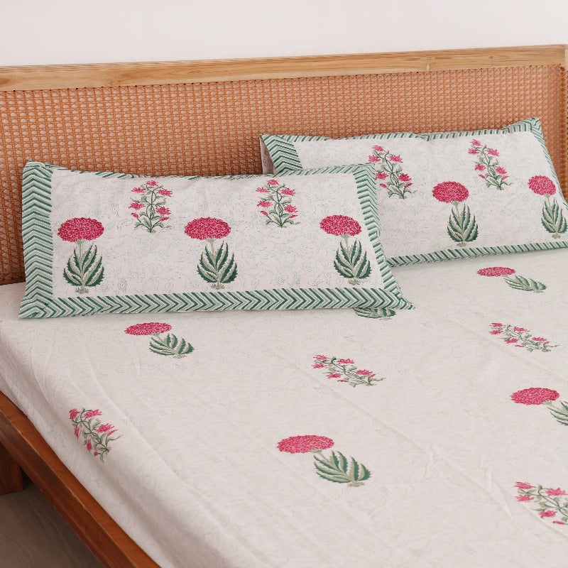 The Block & Bloom Spring Bloom hand block printed cotton percale fitted sheet set with floral pillowcases on a bed.