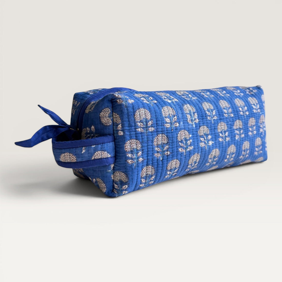 The Block & Bloom Indigo Marigold quilted hair tool organizer bag in blue with white floral block-print pattern.