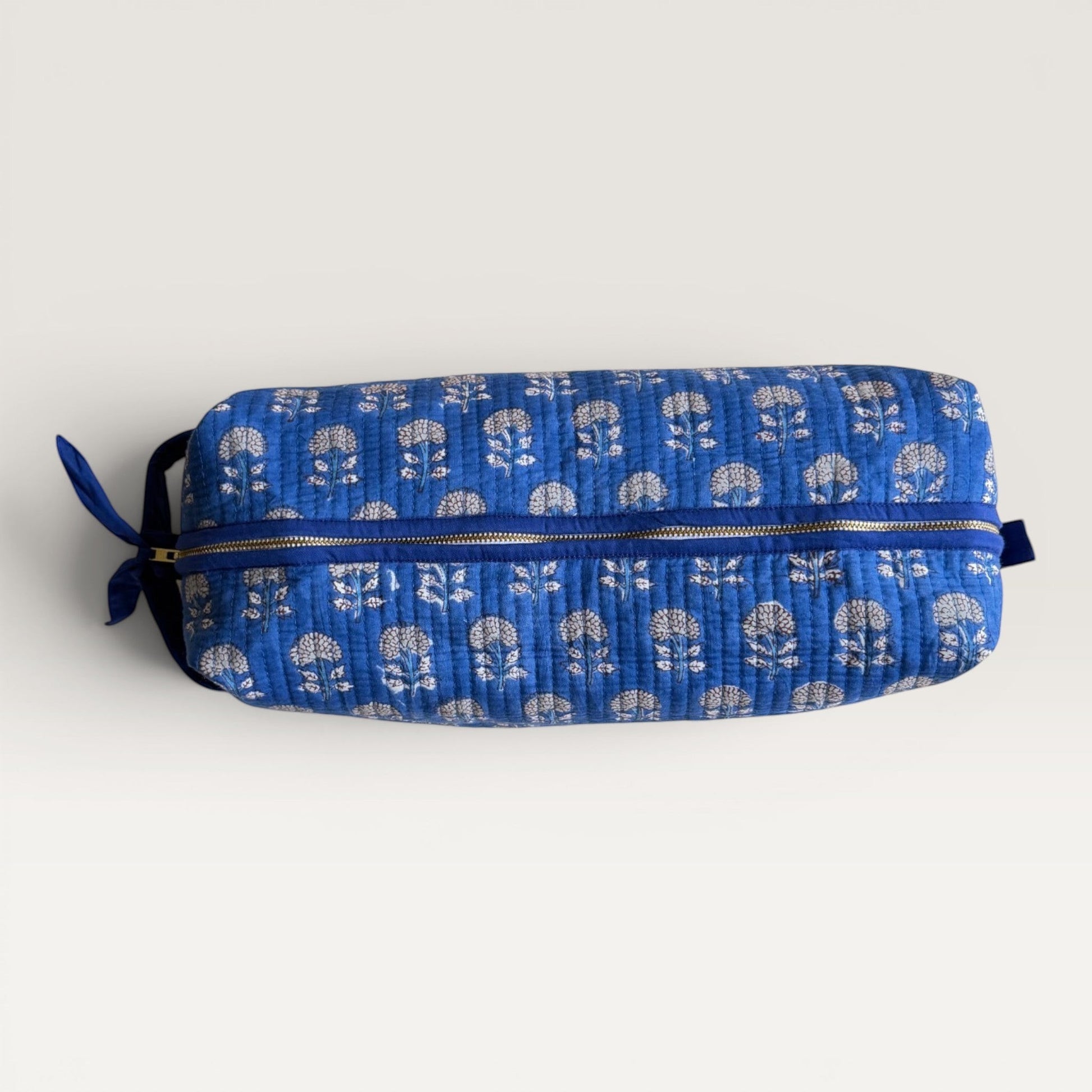 The Block & Bloom Indigo Marigold quilted hair tool organizer bag with white floral print and a secure YKK zipper.