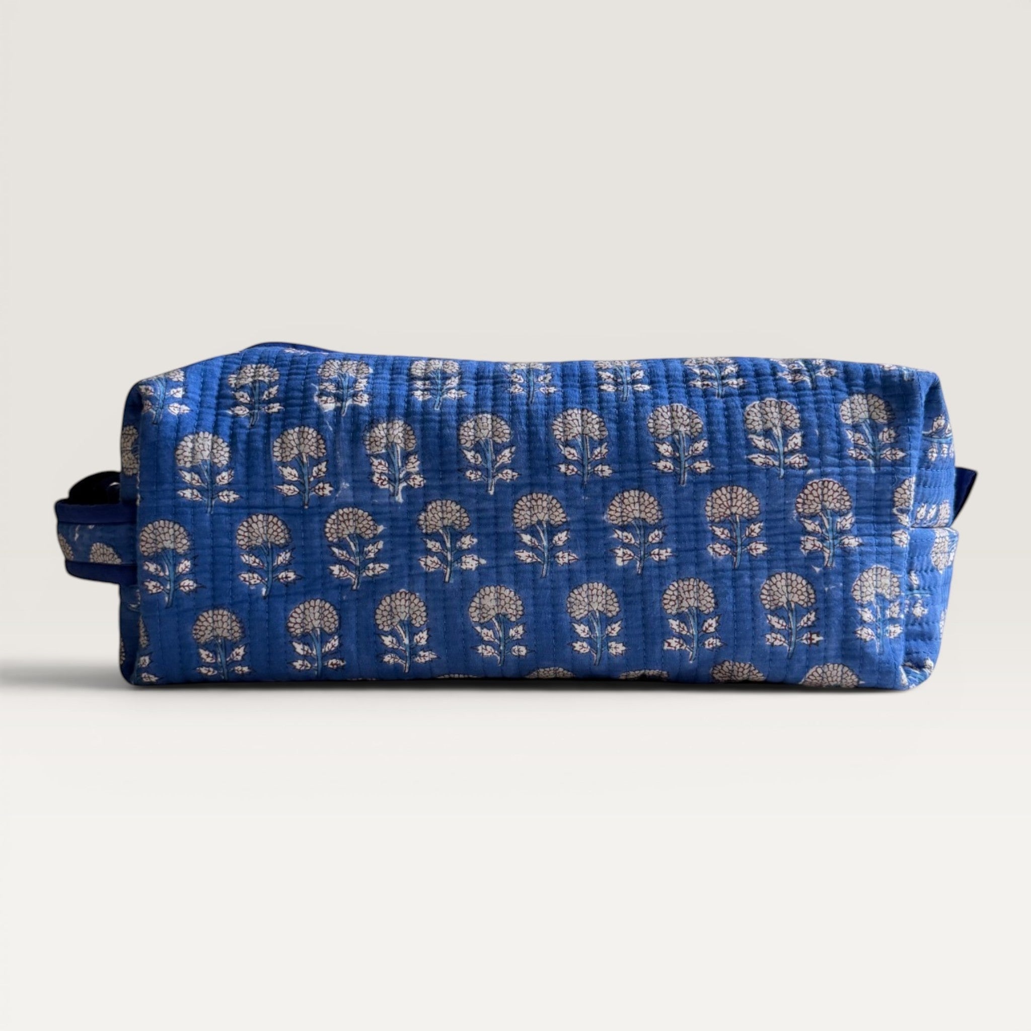 The Block & Bloom Indigo Marigold quilted hair tool organizer bag in blue with white floral block-print pattern.