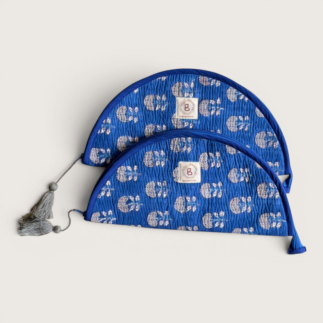 The Block & Bloom indigo blue quilted cotton makeup brush pouch featuring a white marigold floral print and tassels.