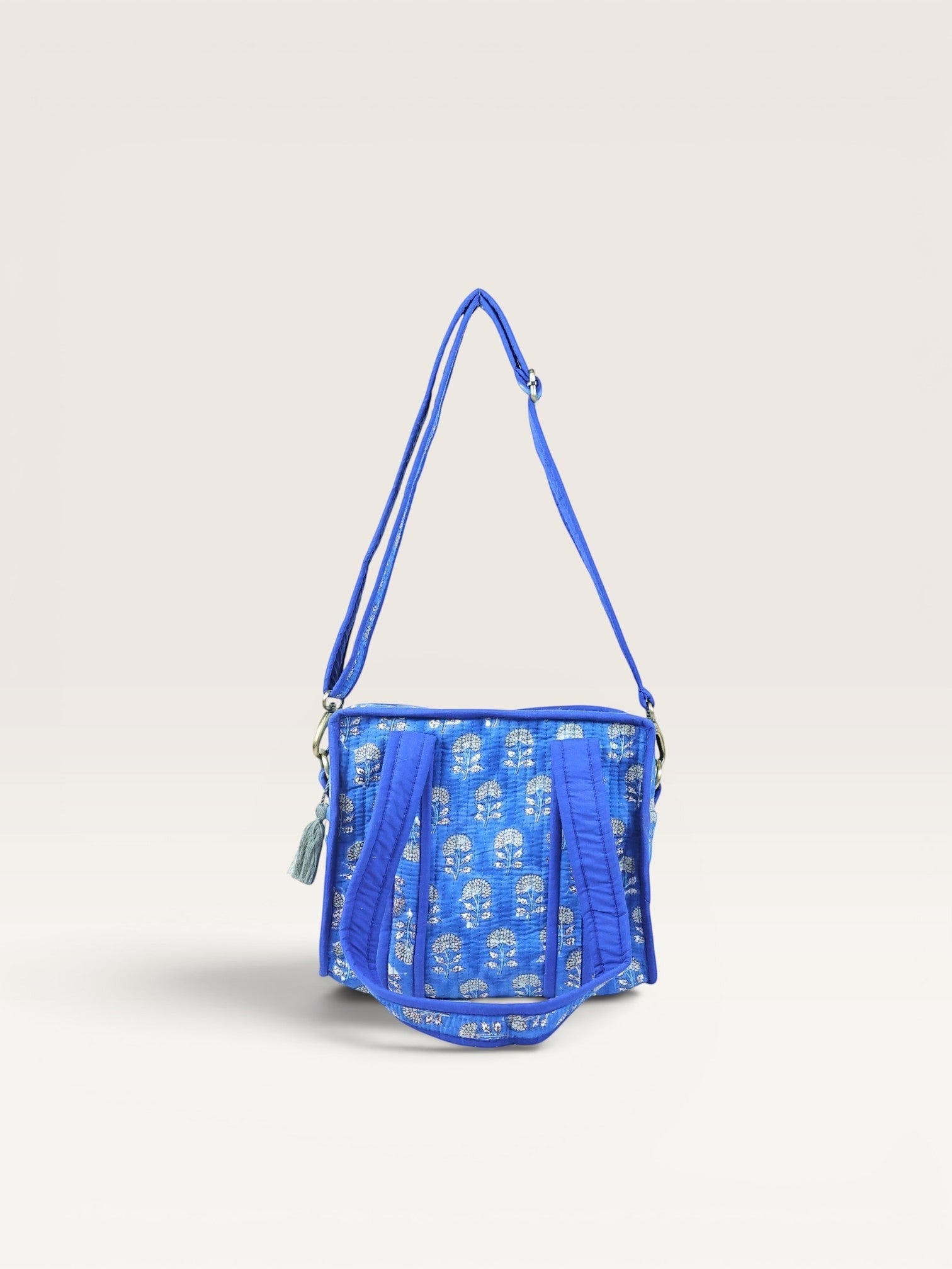 The Block & Bloom quilted mini tote in indigo blue with white marigold block print, featuring a crossbody strap.