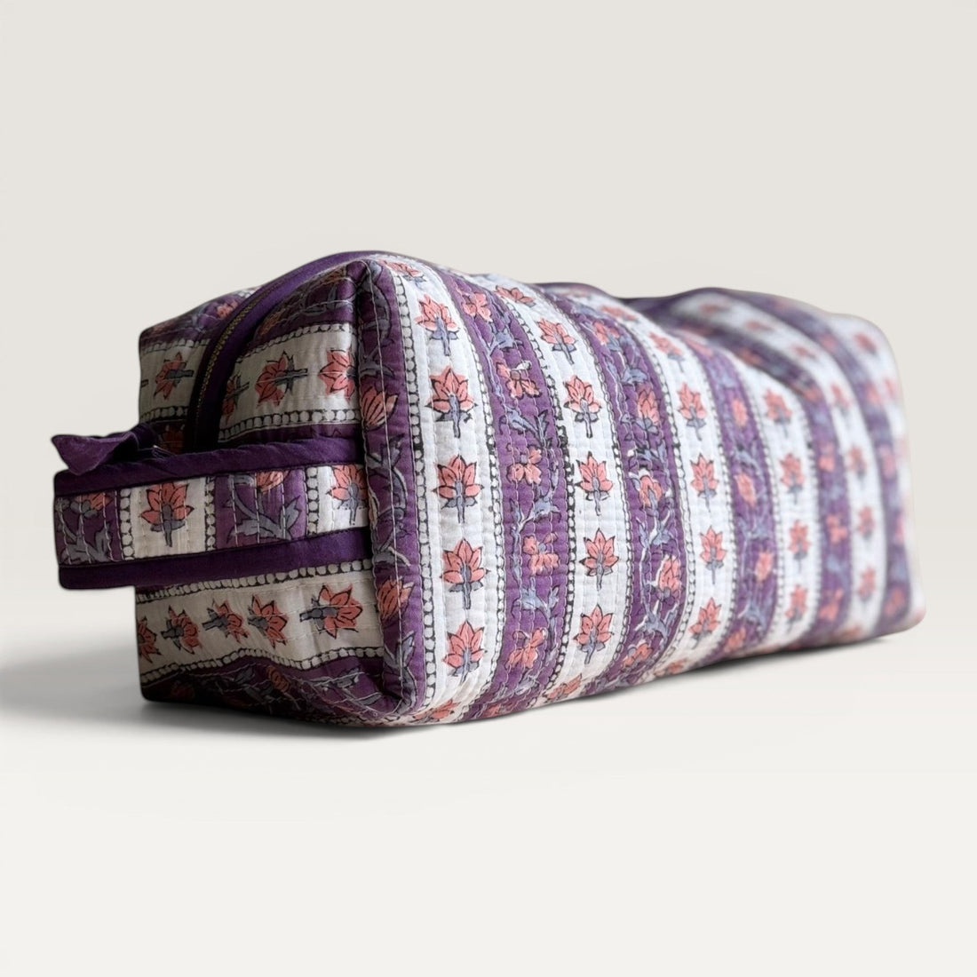 The Block & Bloom quilted hair tool organizer bag in lavender floral vine print with a hair styling tool accessory.
