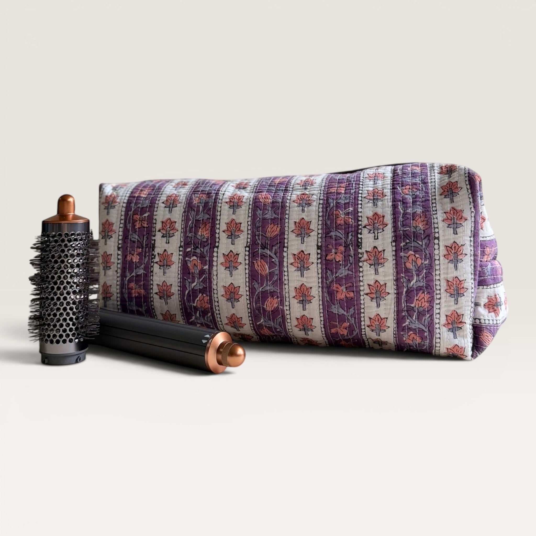 The Block & Bloom quilted hair tool organizer bag in lavender floral vine print with a hair styling tool accessory.