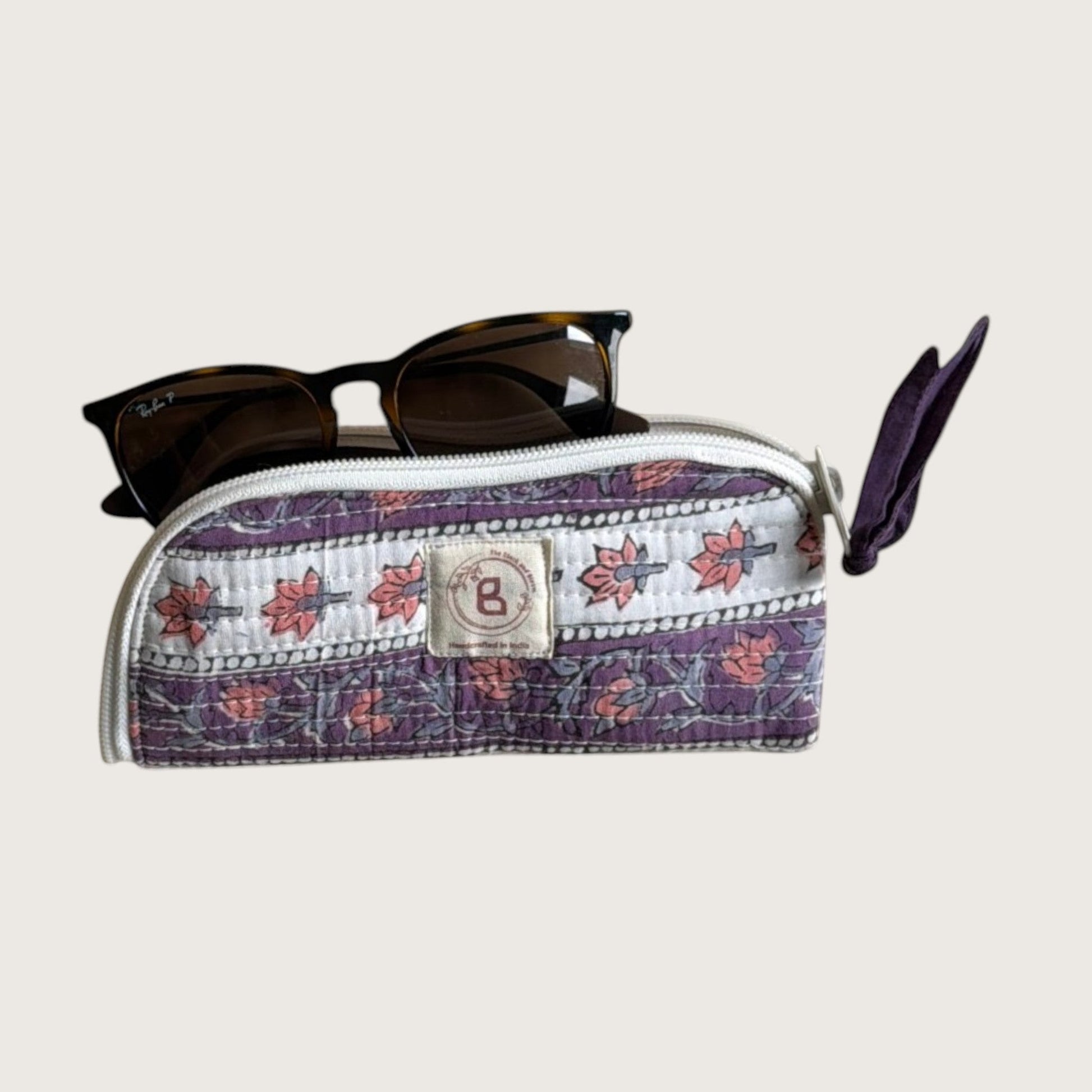 The Block & Bloom quilted cotton sunglasses pouch in lavender with floral vines and a hand-stitched fabric bow zipper.