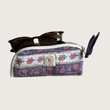 The Block & Bloom quilted cotton sunglasses pouch in lavender with floral vines and a hand-stitched fabric bow zipper.