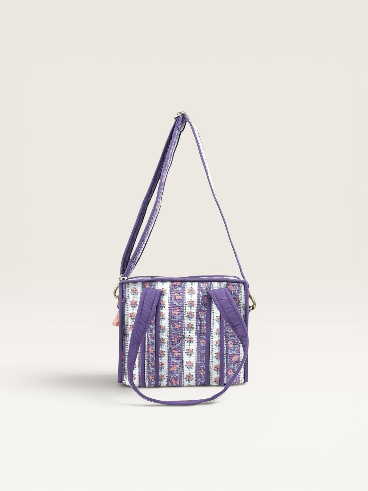 The Block & Bloom quilted mini tote in lavender with white floral vine stripes, padded handles, and crossbody strap.