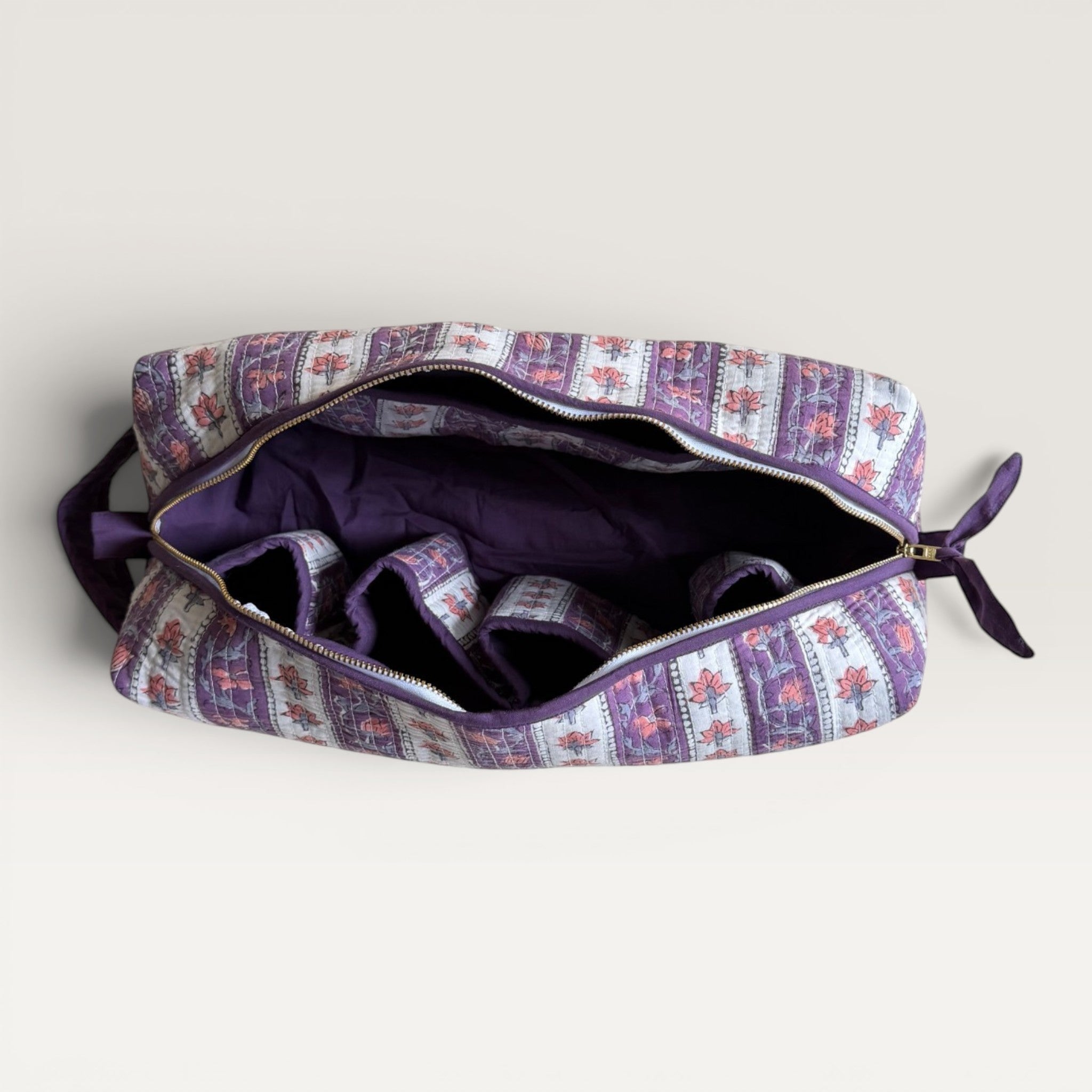 The Block & Bloom quilted lavender hair tool organizer bag with floral vine print and internal storage compartments.