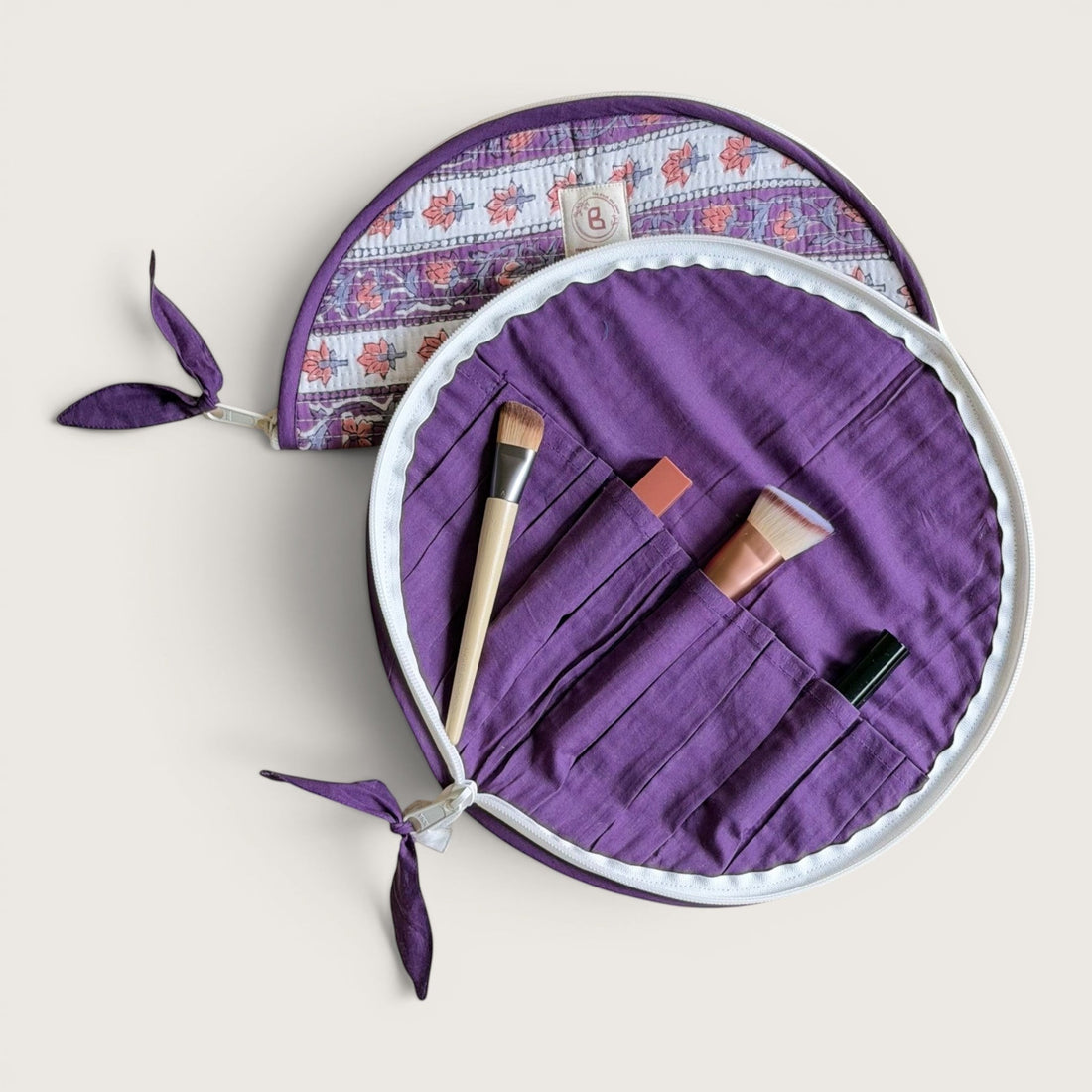 The Block & Bloom lavender quilted cotton makeup brush pouches with floral vine print and purple zipper pulls.