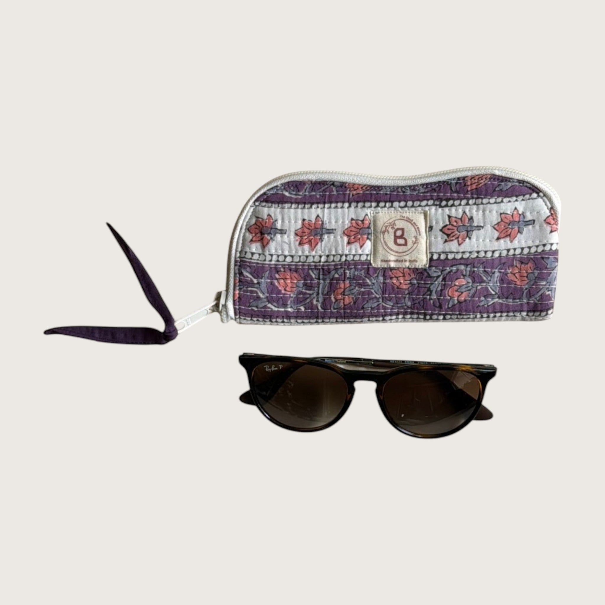 The Block & Bloom quilted cotton sunglasses pouch in lavender with floral vines and a hand-stitched fabric bow zipper.