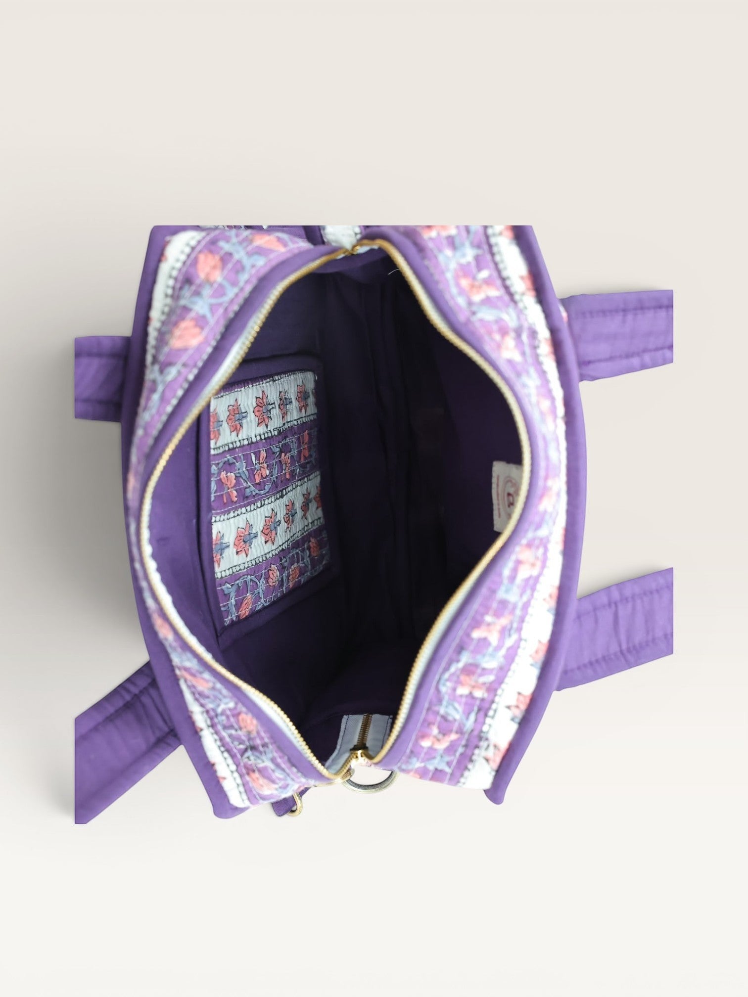 The Block & Bloom Lavender Vine quilted mini tote bag interior view showing purple lining and floral pocket detail.