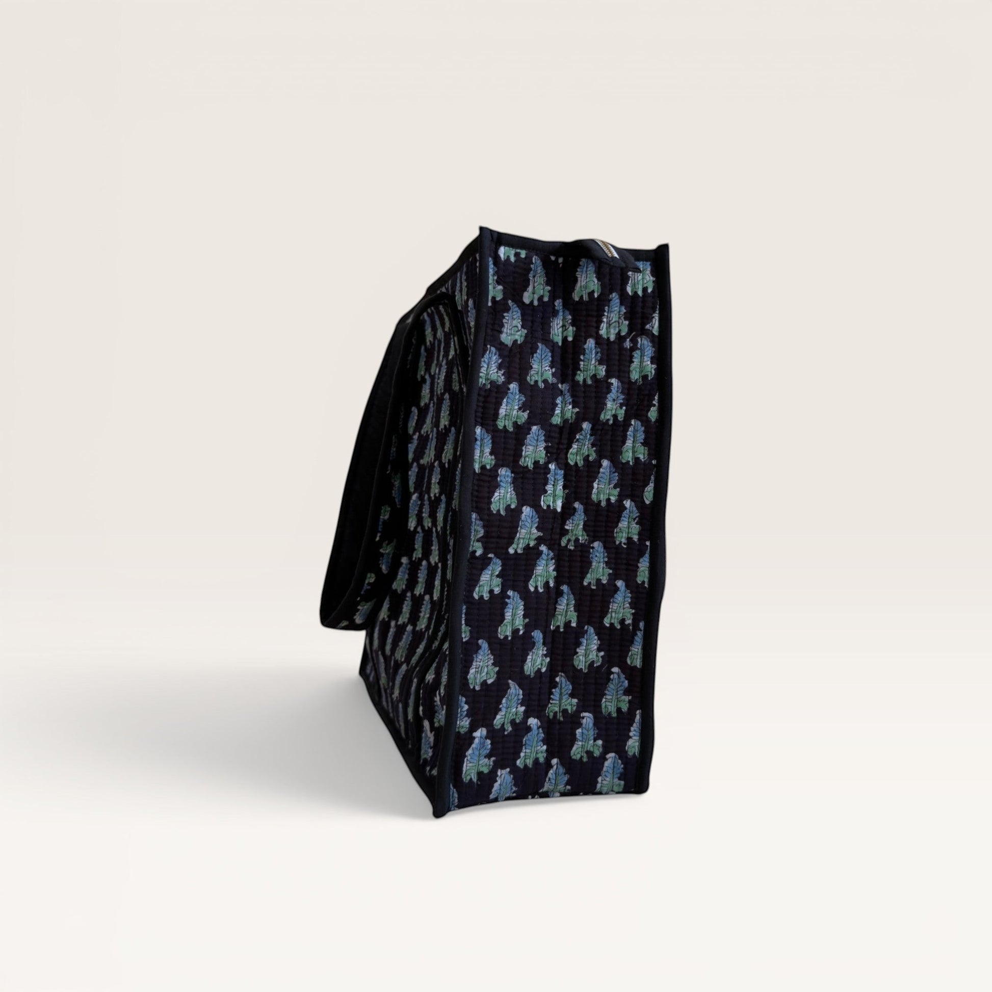 The Block & Bloom Midnight Fern quilted tote in black with blue and sage green leaf print, side profile view.