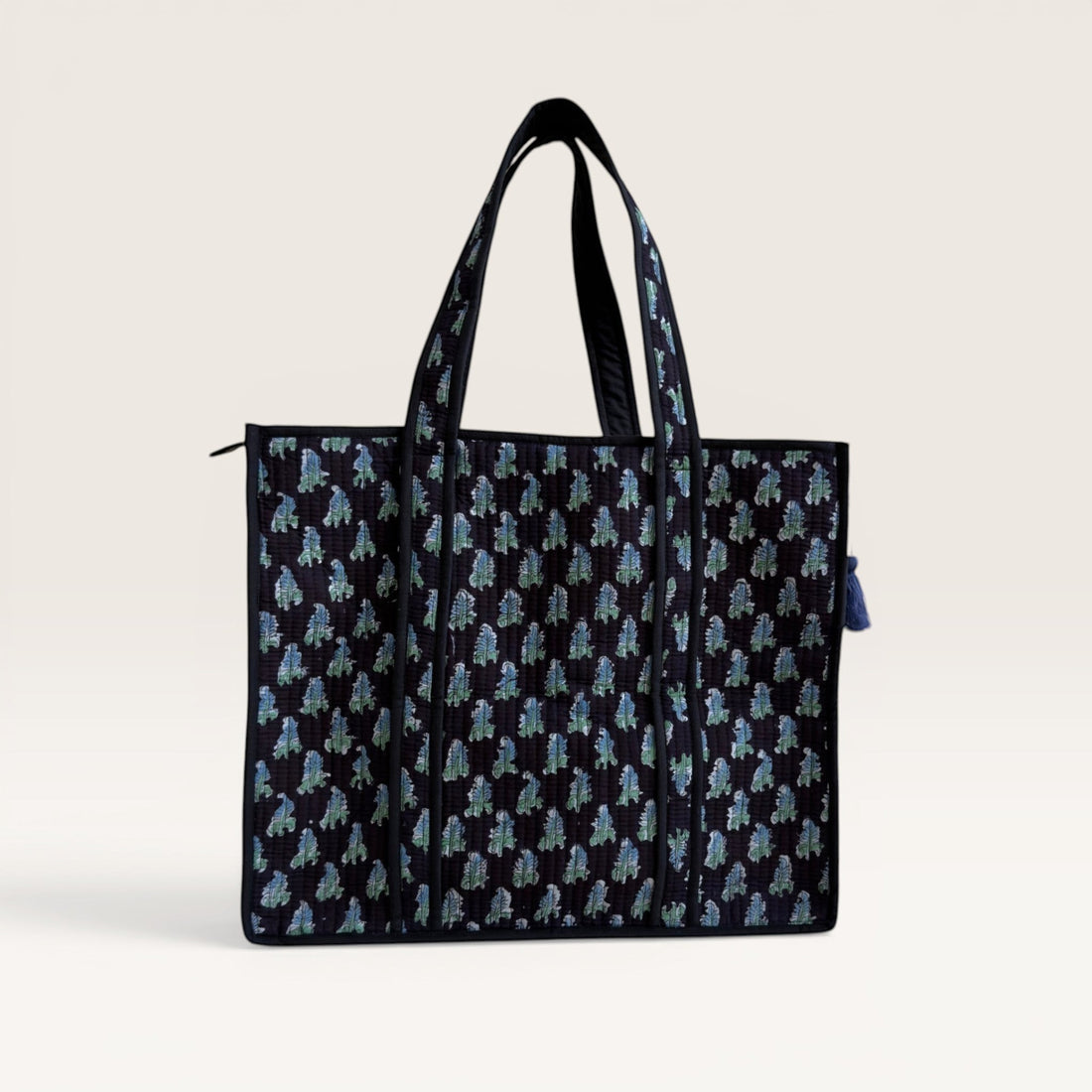 The Block & Bloom Midnight Fern quilted tote bag in black with blue and sage green leaf print and structured base.