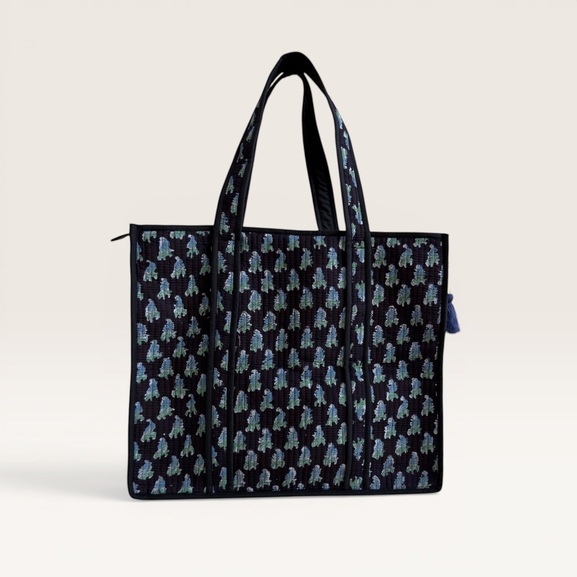 The Block & Bloom Midnight Fern quilted tote bag in black with blue and sage green leaf print and structured base.