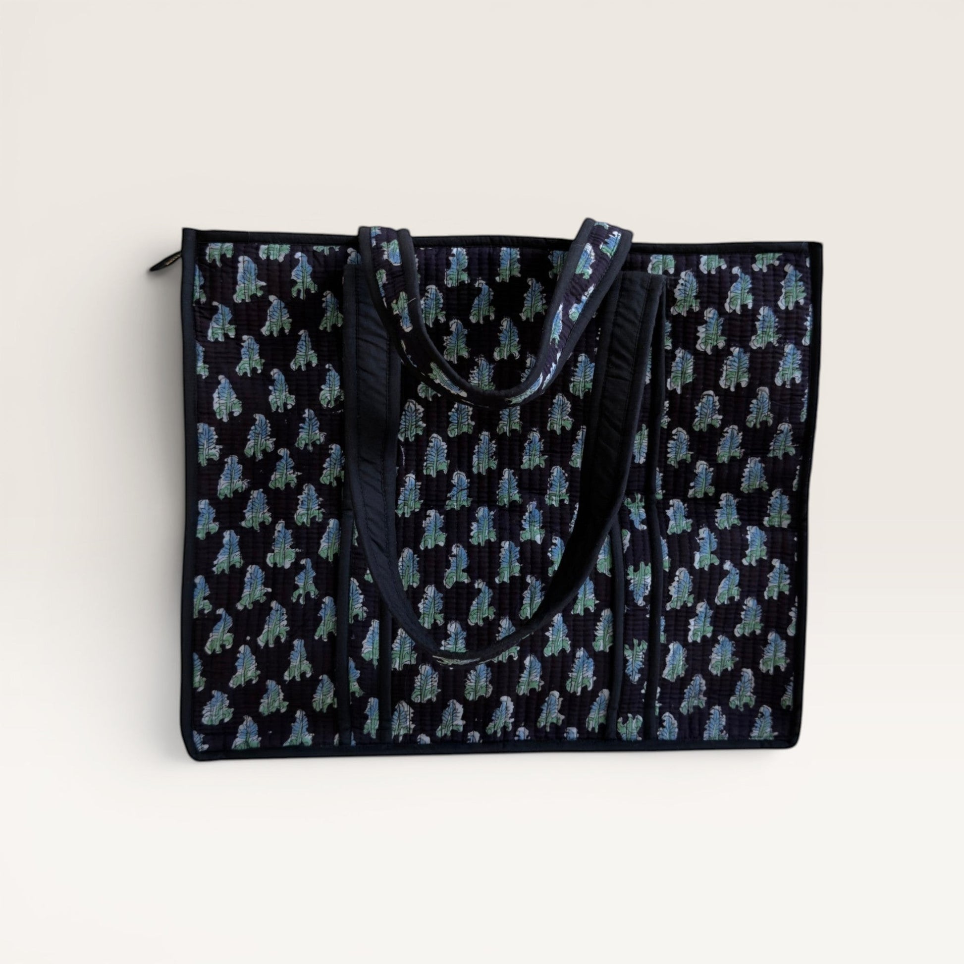 The Block & Bloom Midnight Fern quilted tote bag in black with blue and sage green leaf print and structured base.