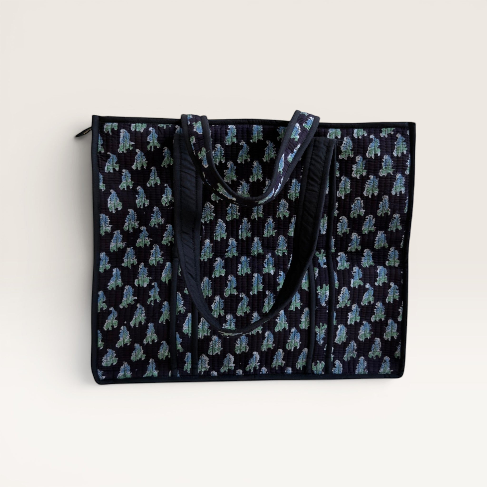 The Block & Bloom Midnight Fern quilted tote bag in black with blue and sage green leaf print and structured base.