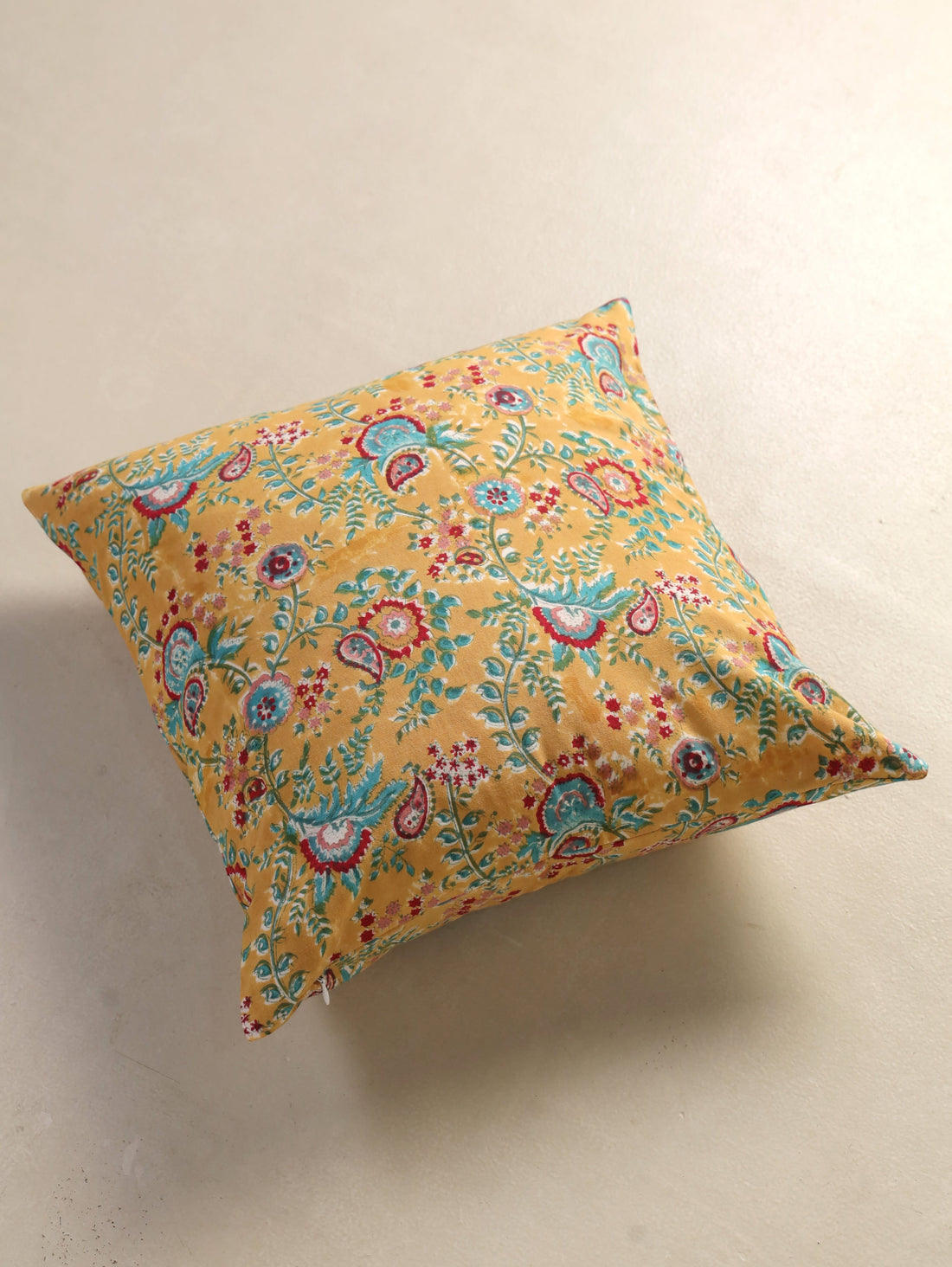 The Block & Bloom mustard cotton cushion cover featuring hand block printed teal and crimson paisley and floral motifs.