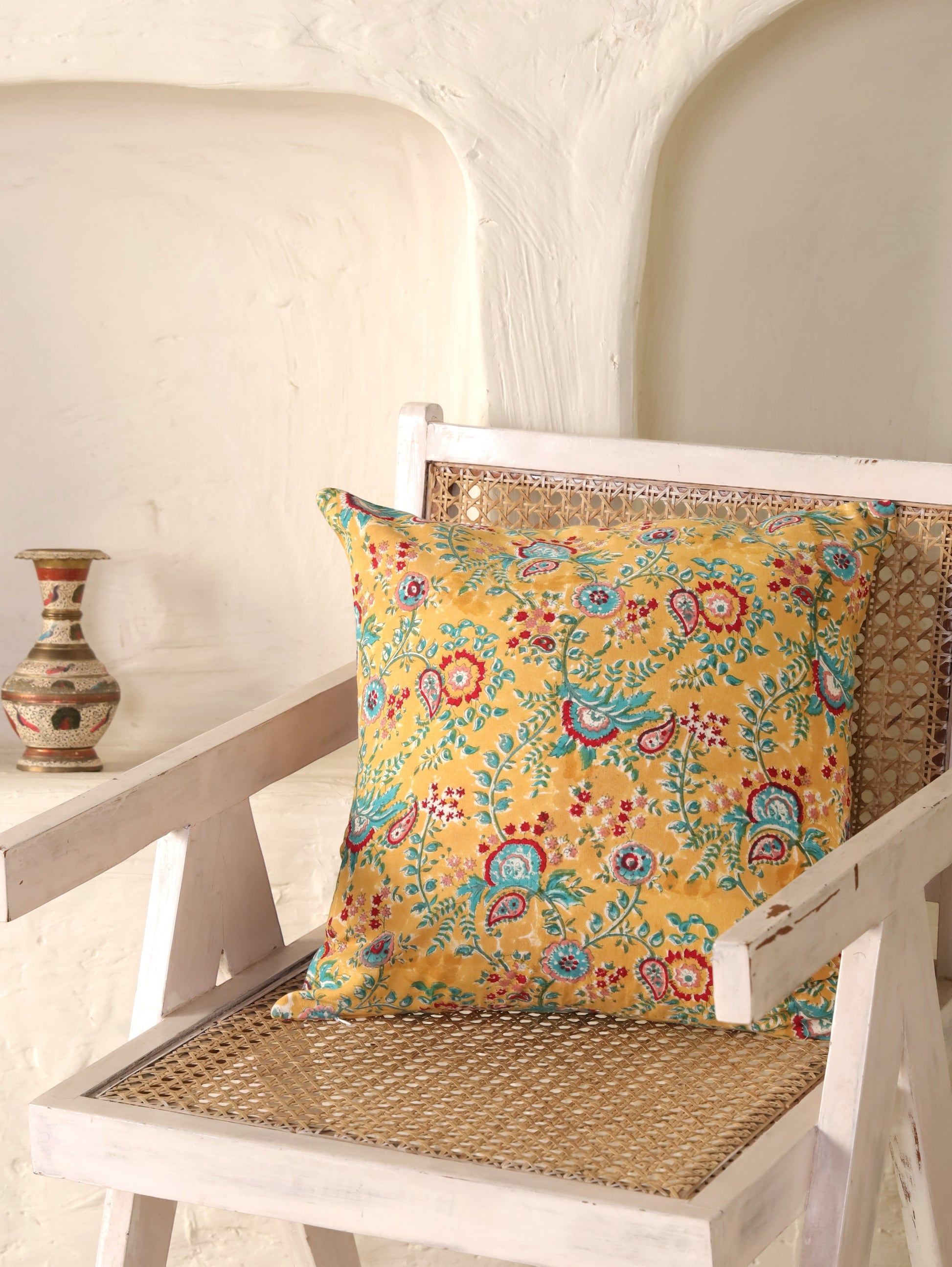 The Block & Bloom mustard cotton cushion cover with hand block printed teal and crimson paisley and floral patterns.