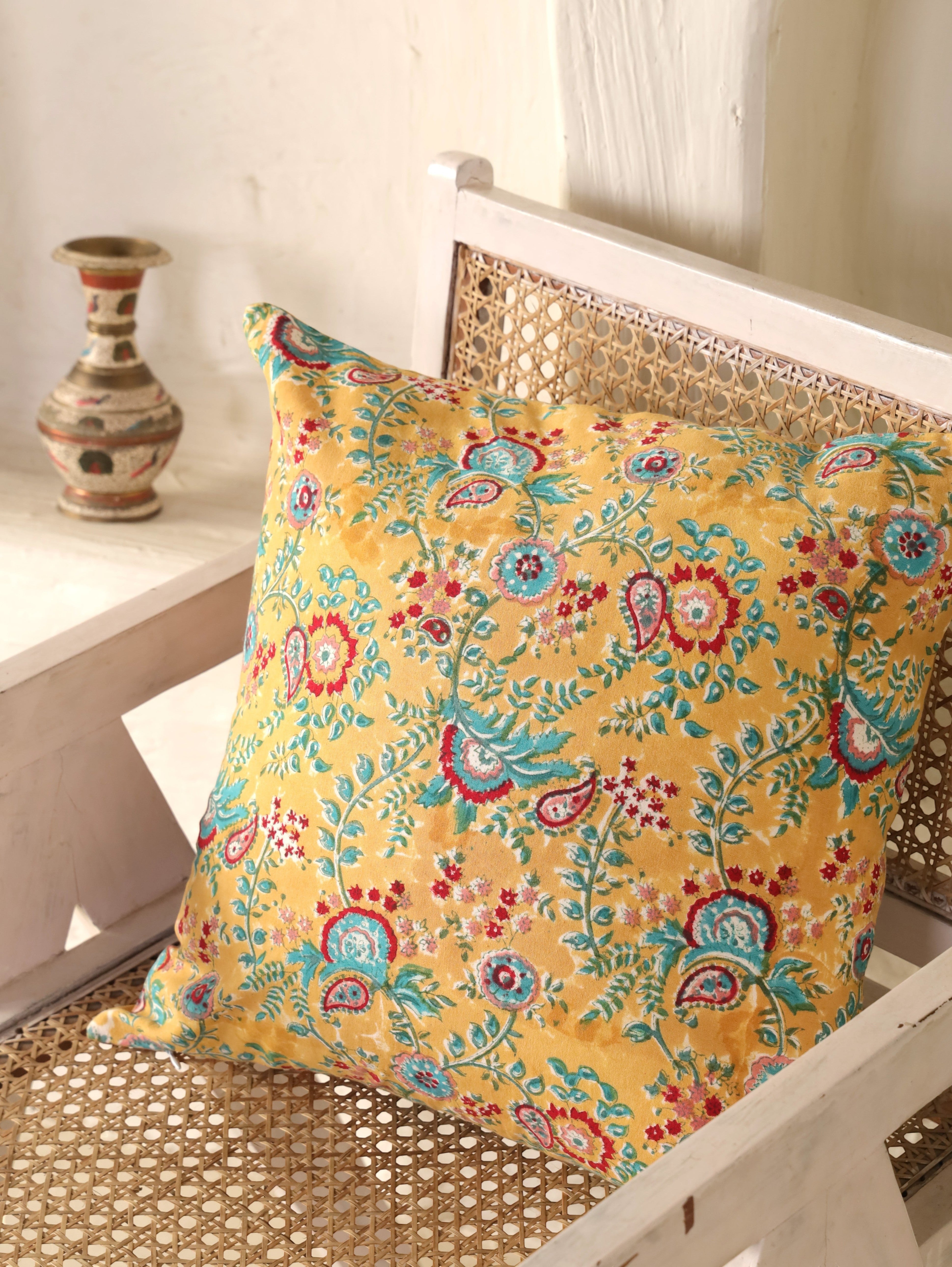 The Block & Bloom mustard cotton cushion cover featuring hand block printed teal and crimson paisley floral patterns.