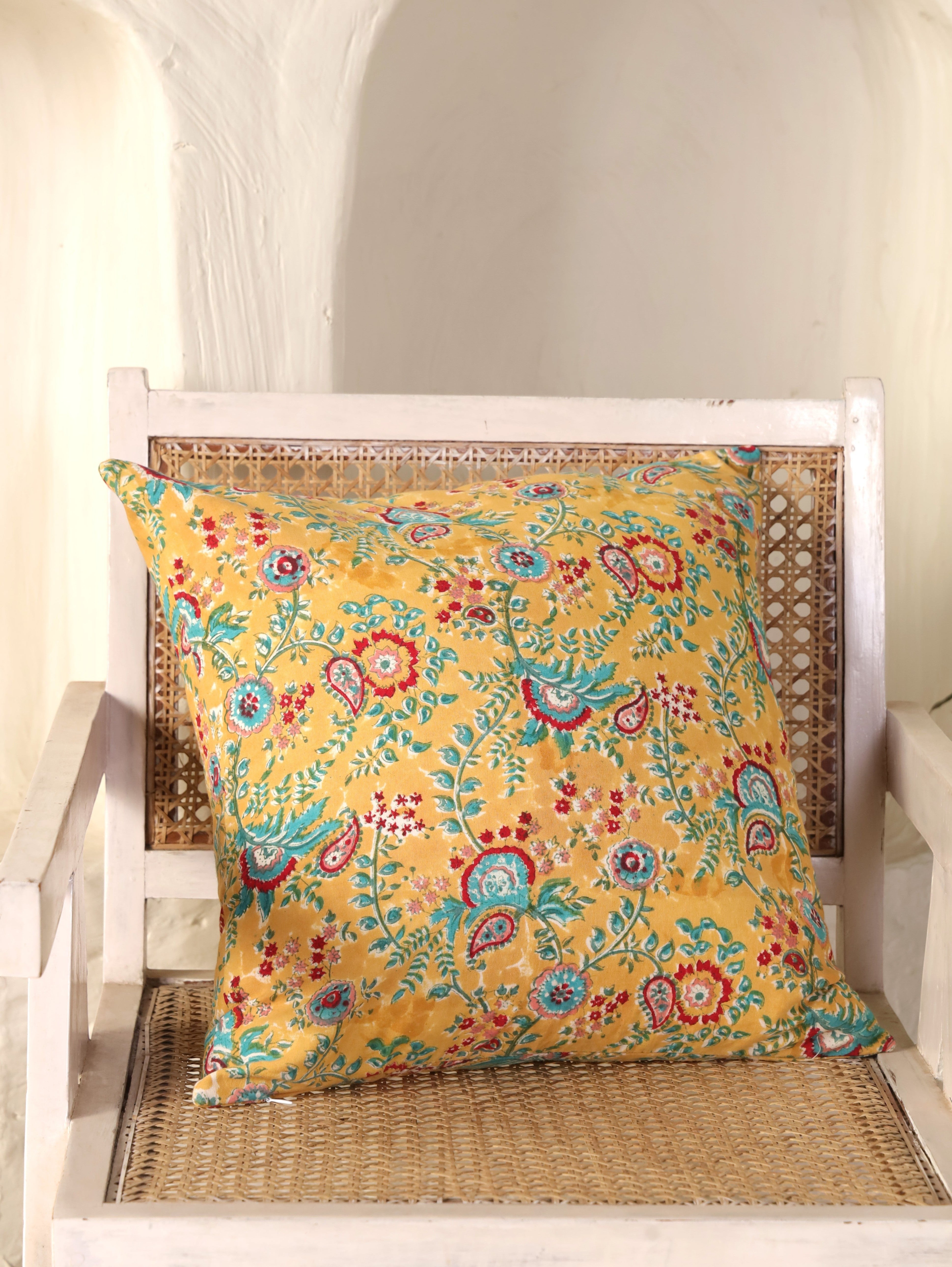 The Block & Bloom mustard cotton cushion cover featuring hand block printed paisley, floral, and fern motifs.